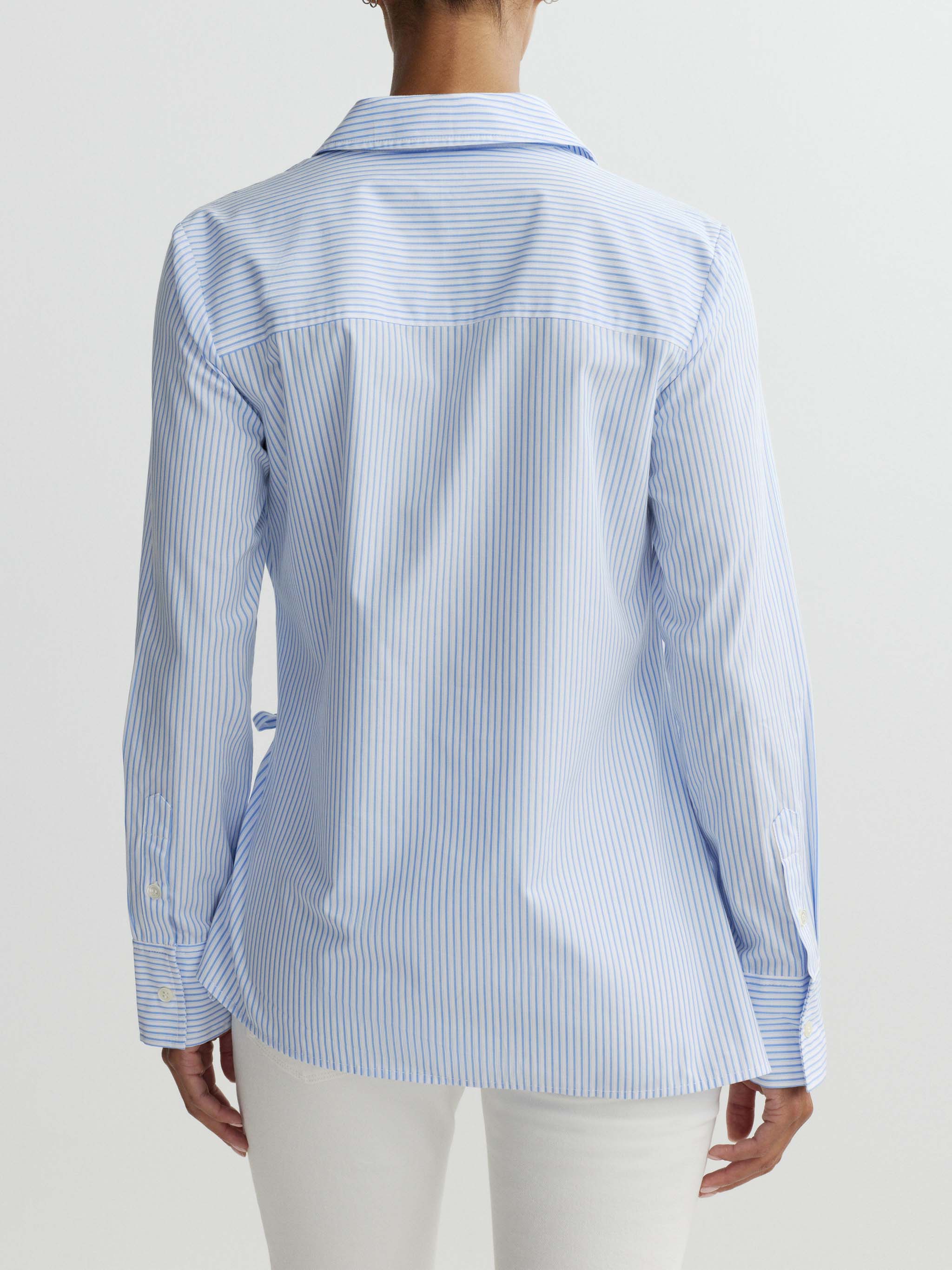 Blue and white striped shirt worn by a person on a plain background