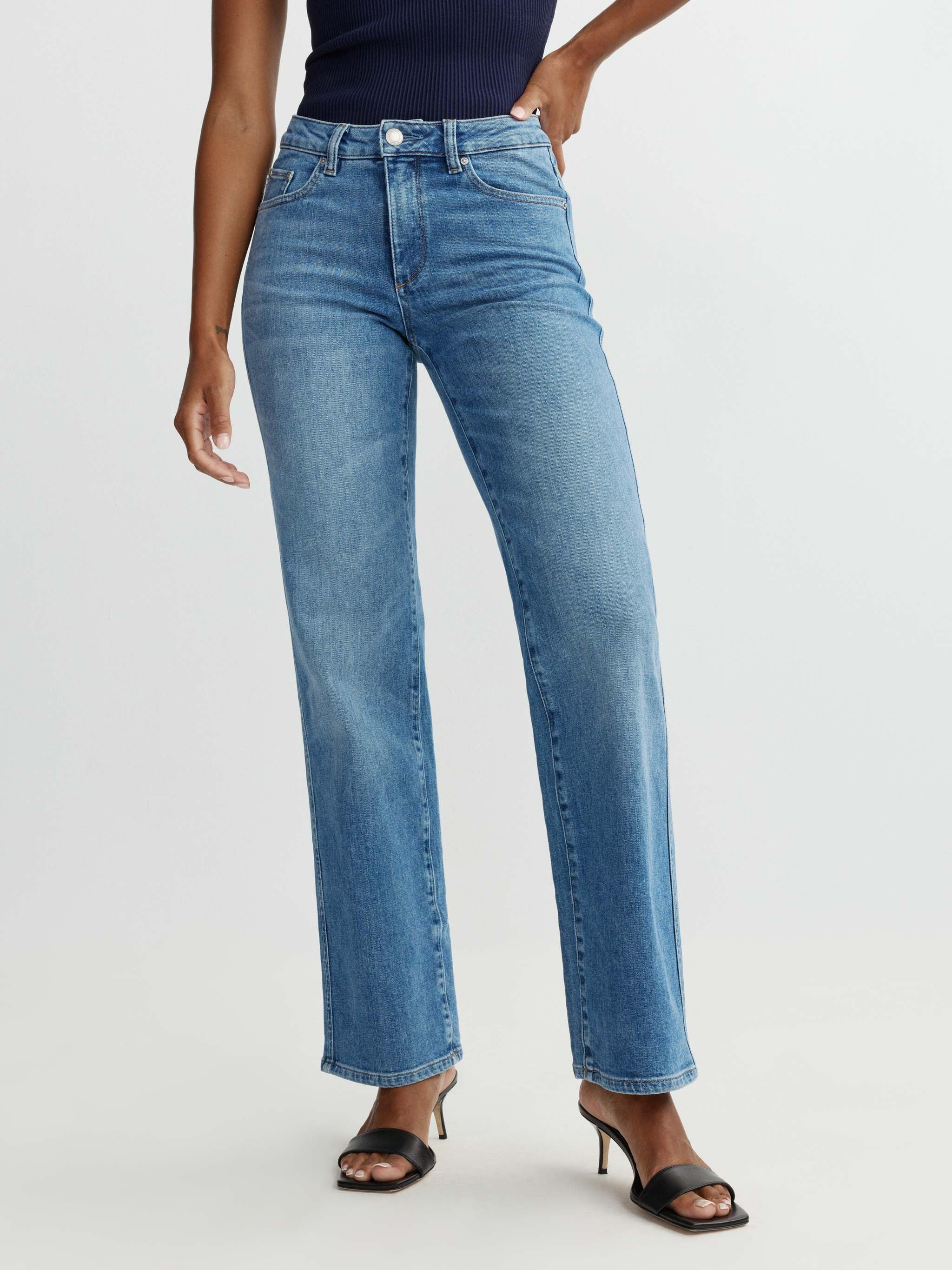 Person wearing blue jeans on a white background