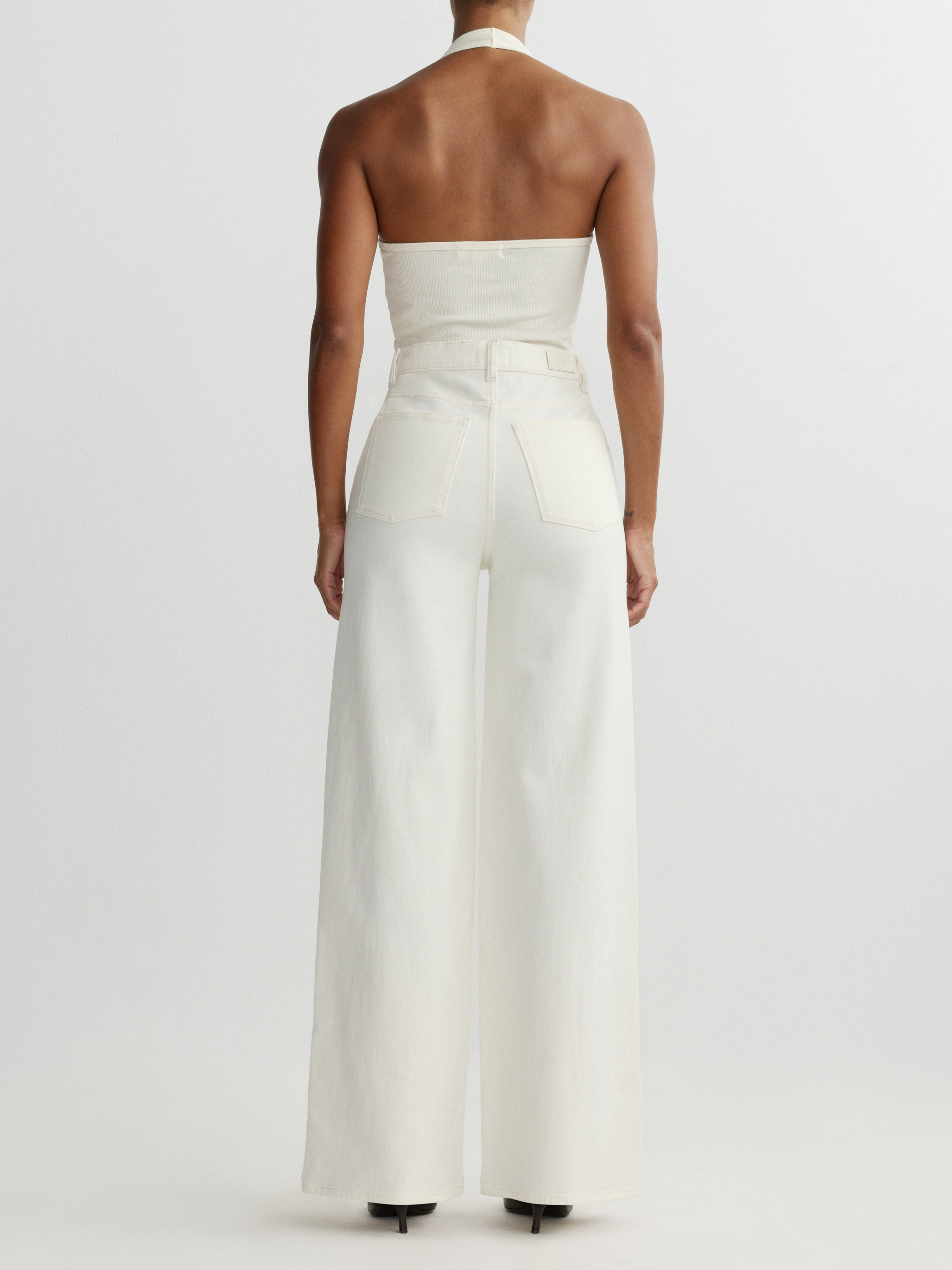 White halter neck jumpsuit on a plain background