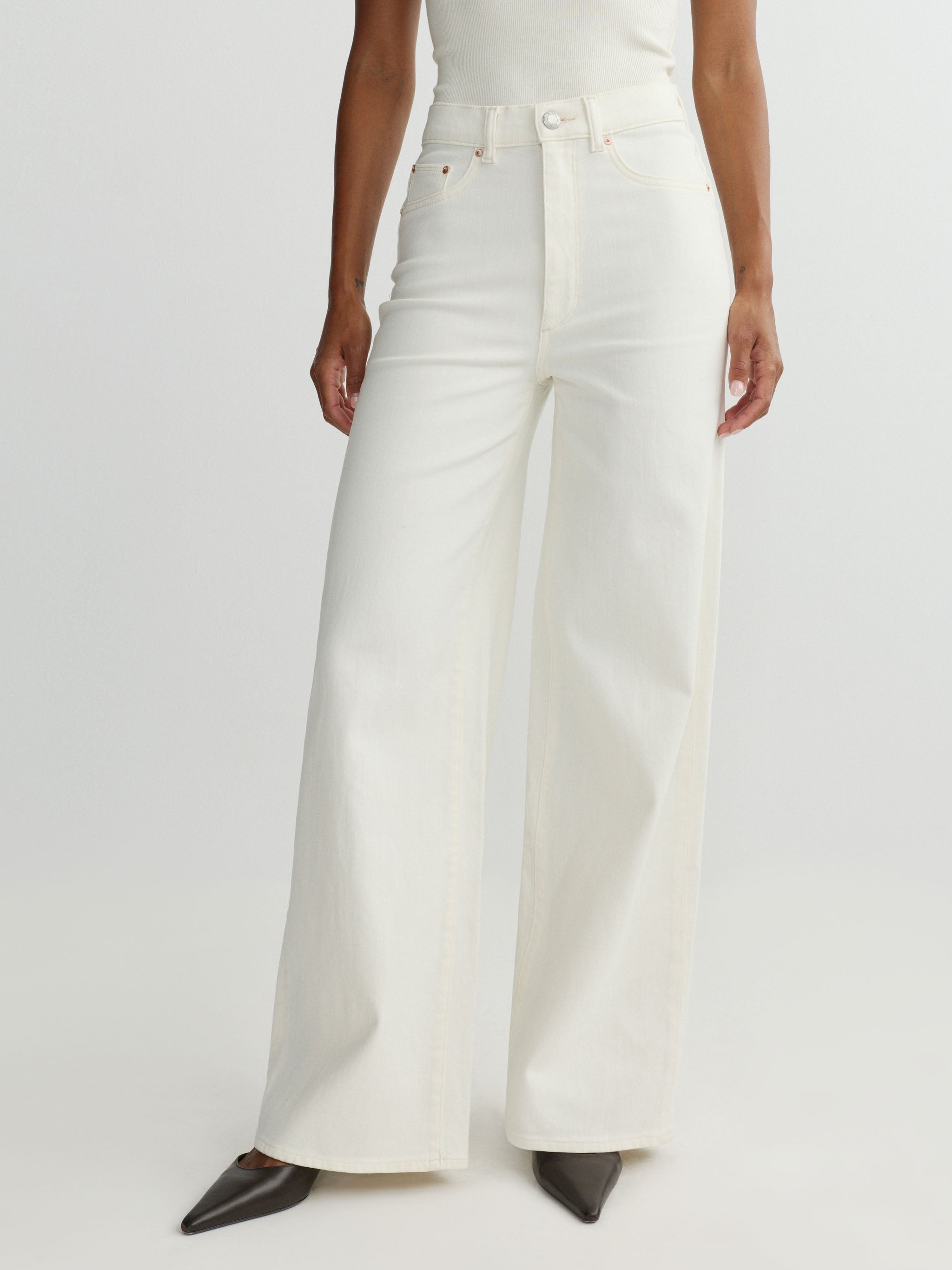 Person wearing white wide-leg pants on a plain background