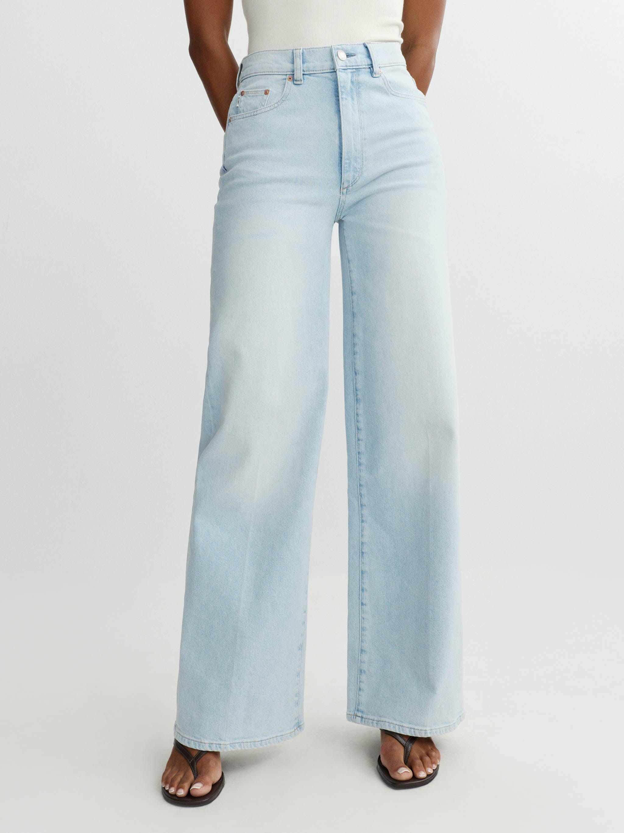 Light blue jeans worn by a person on a white background