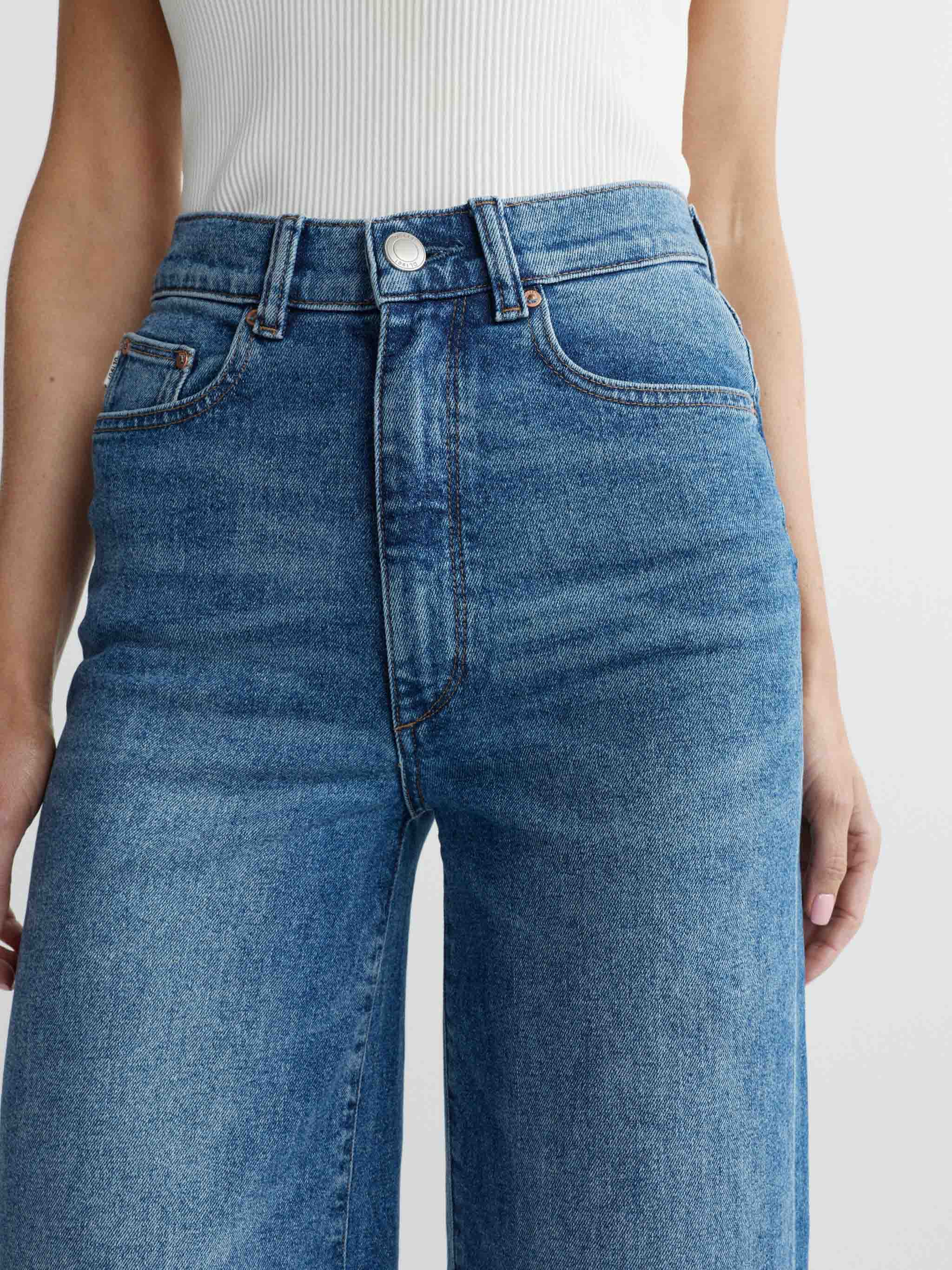 Blue jeans worn by a person on a white background