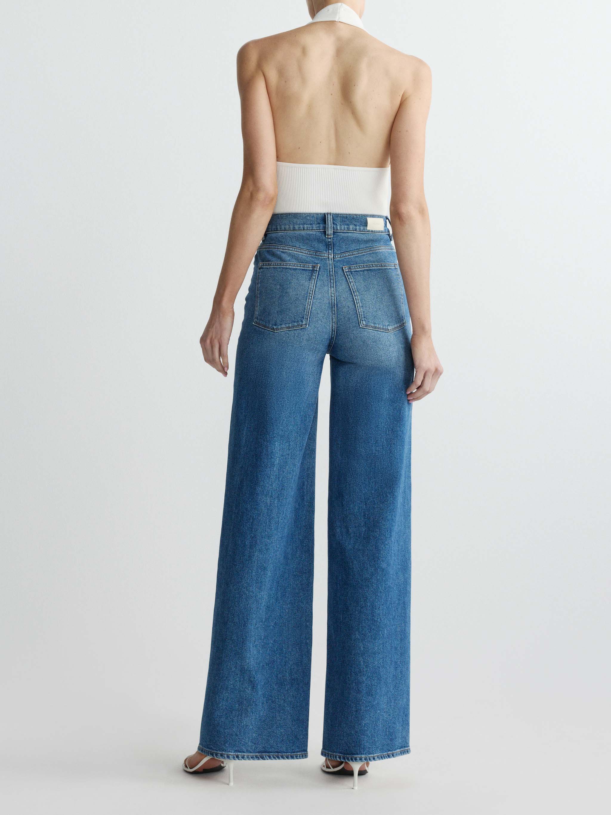 Person wearing blue jeans on a white background
