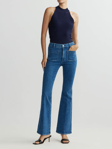 Person wearing blue jeans and a navy sleeveless top on a light gray background