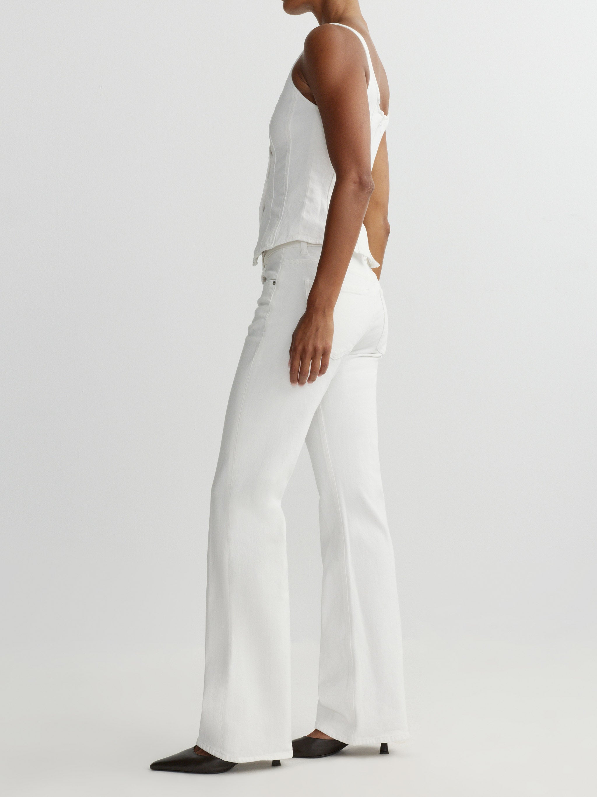 Person wearing a white top and pants on a plain background