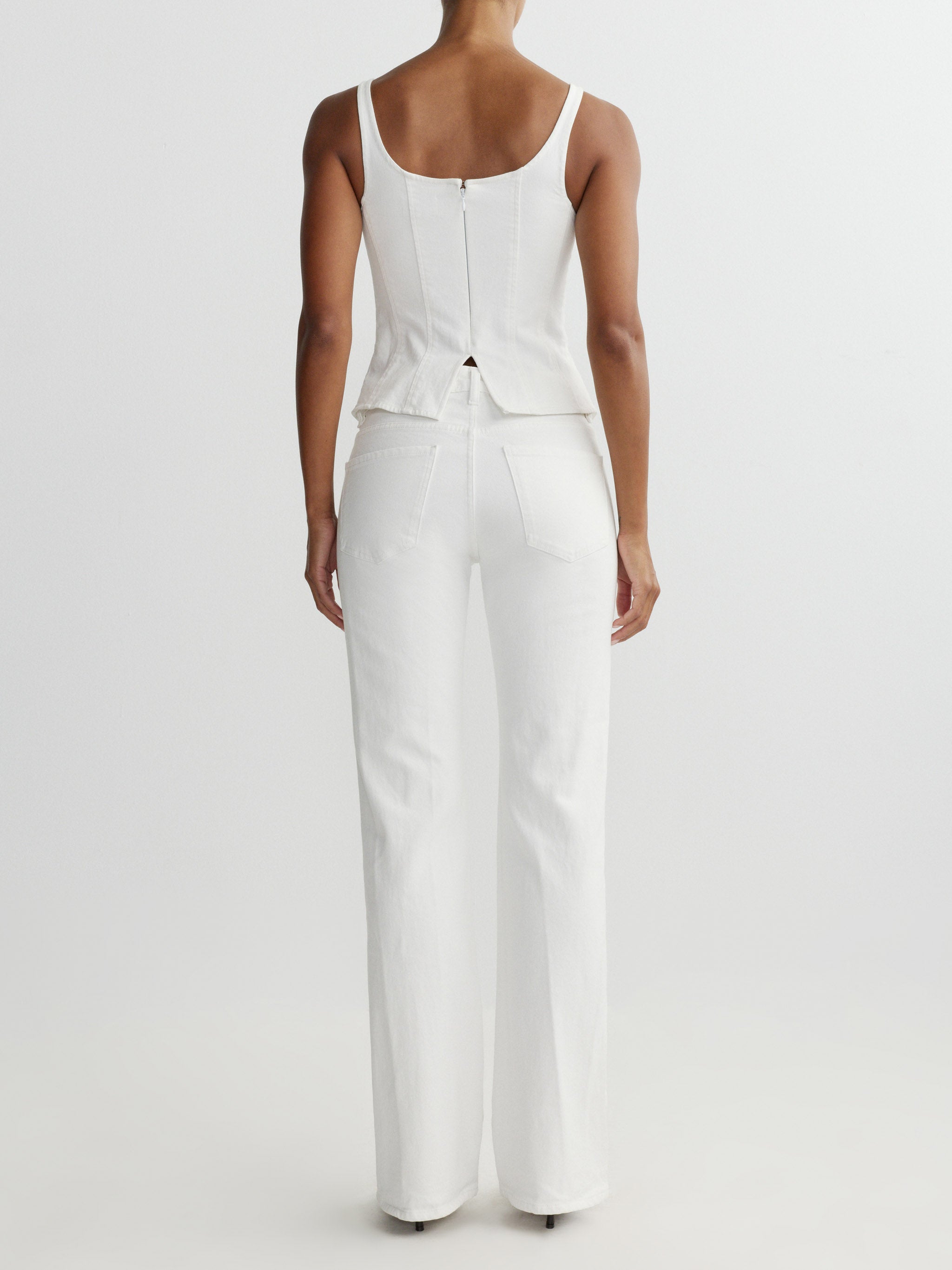 Person wearing a white top and pants on a plain background