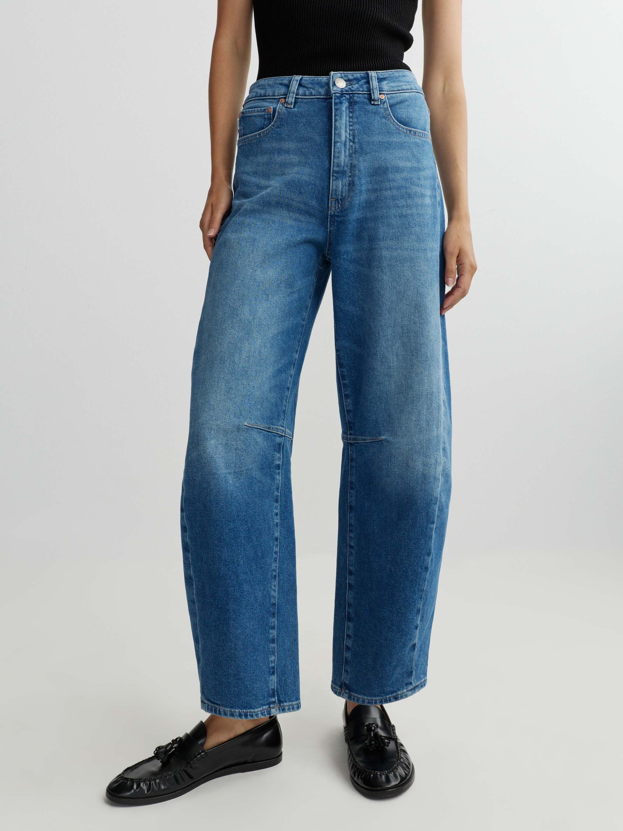 Person wearing blue jeans on a white background