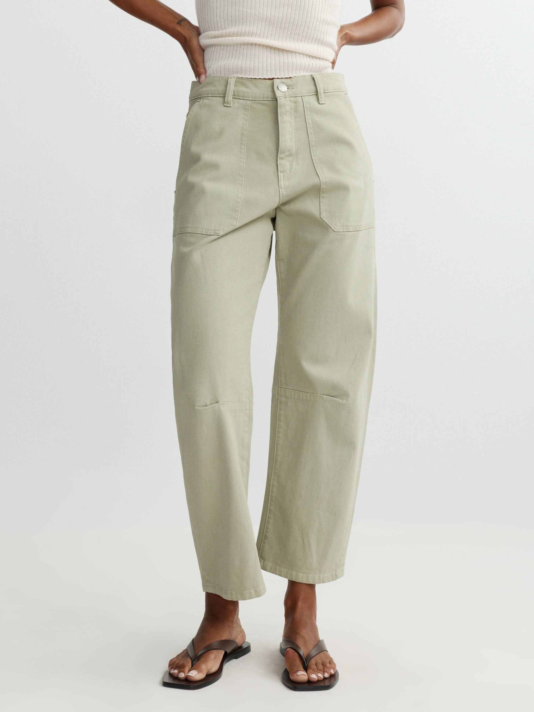 Person wearing light green pants on a white background