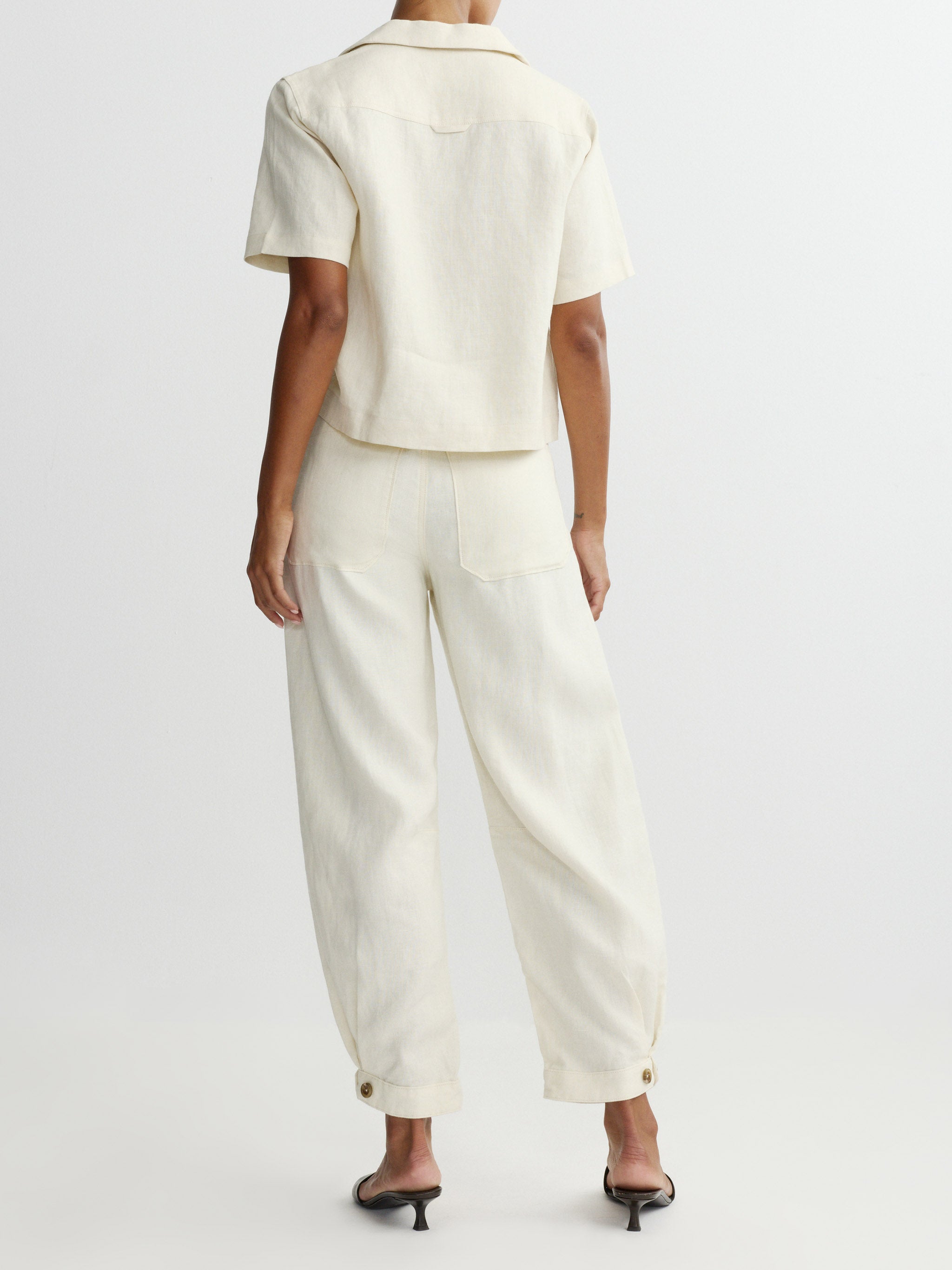 Person wearing a white outfit with a plain background