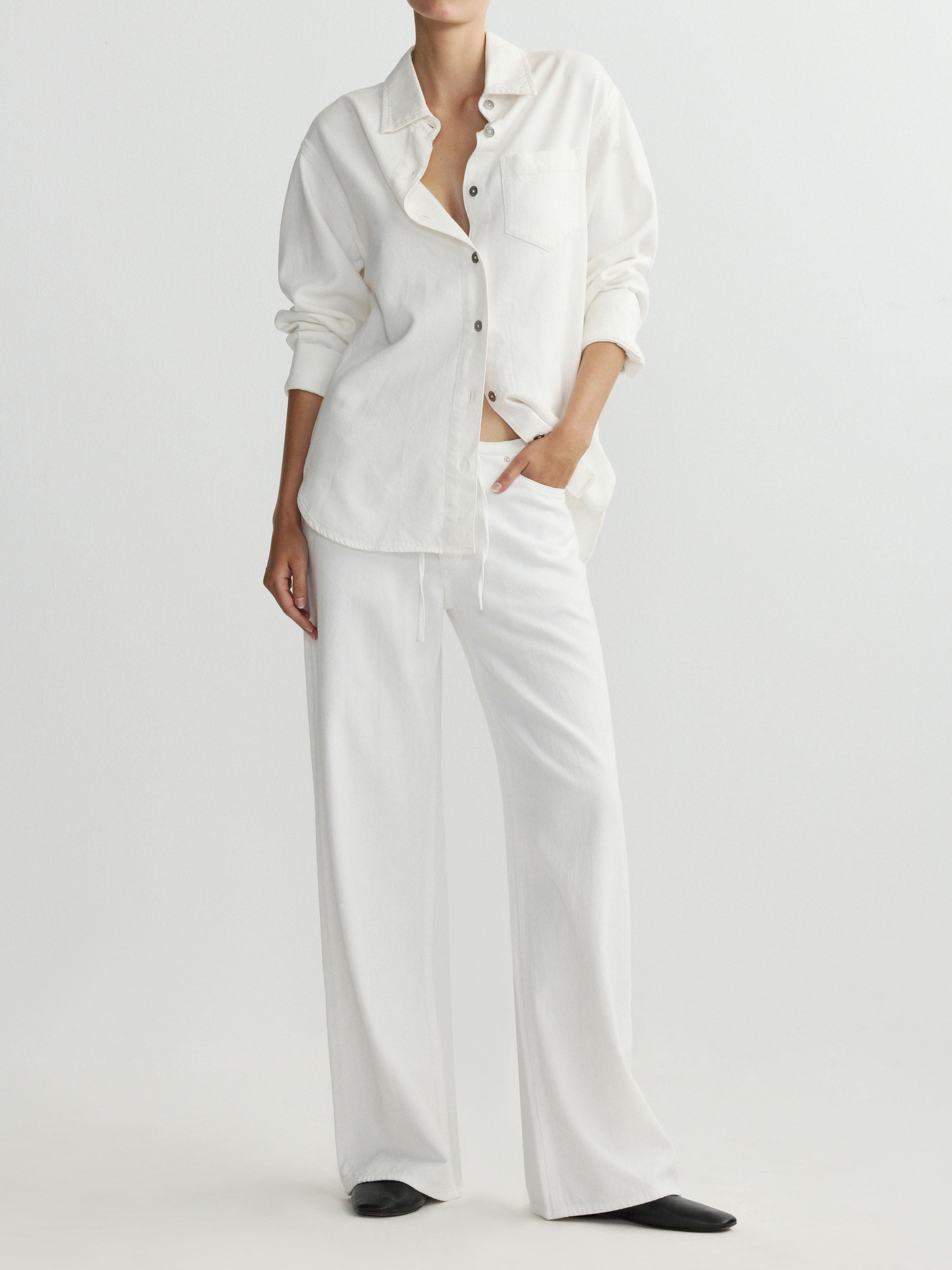 Person wearing a white outfit on a plain background