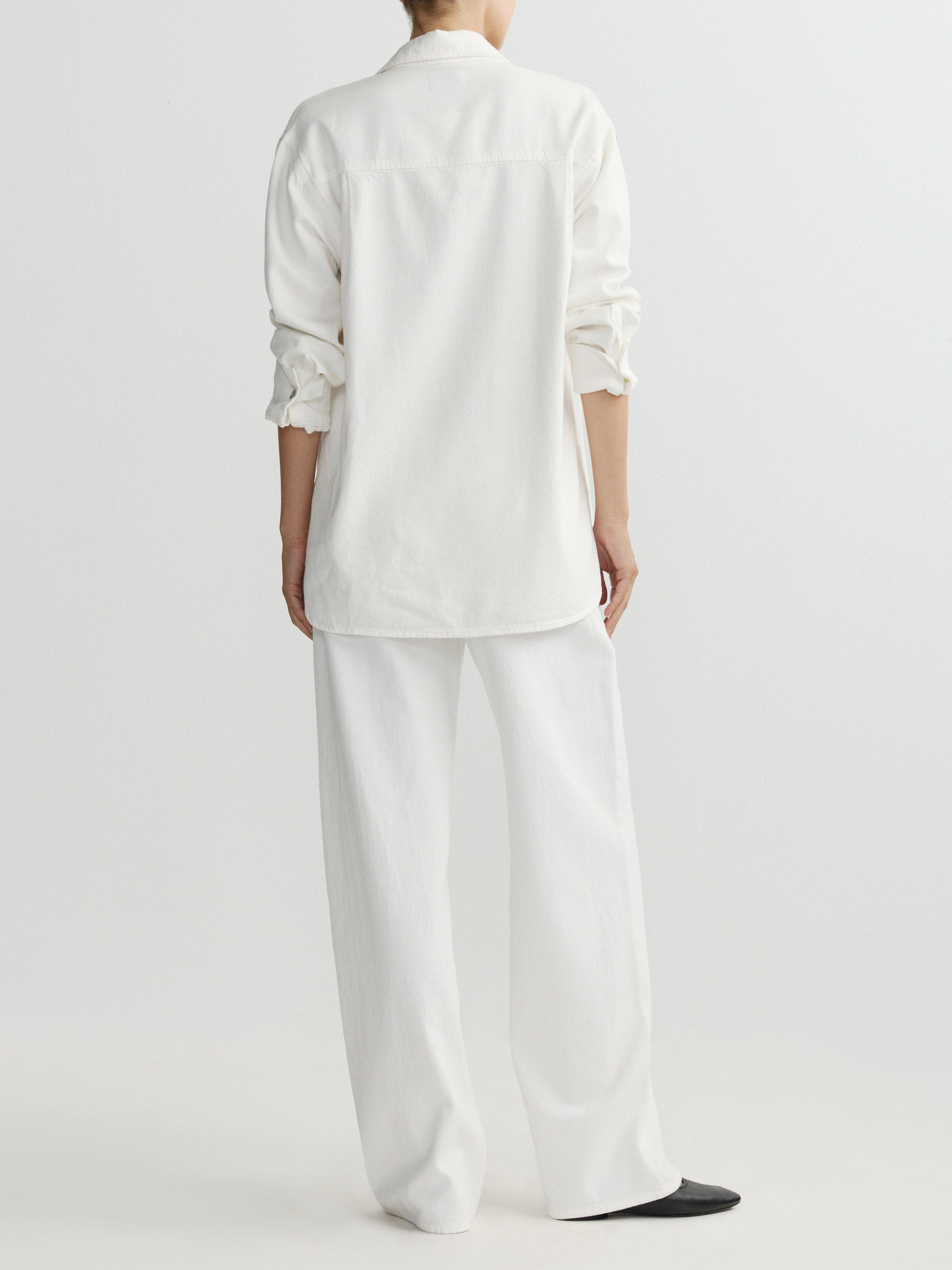 Person wearing a white outfit on a plain background