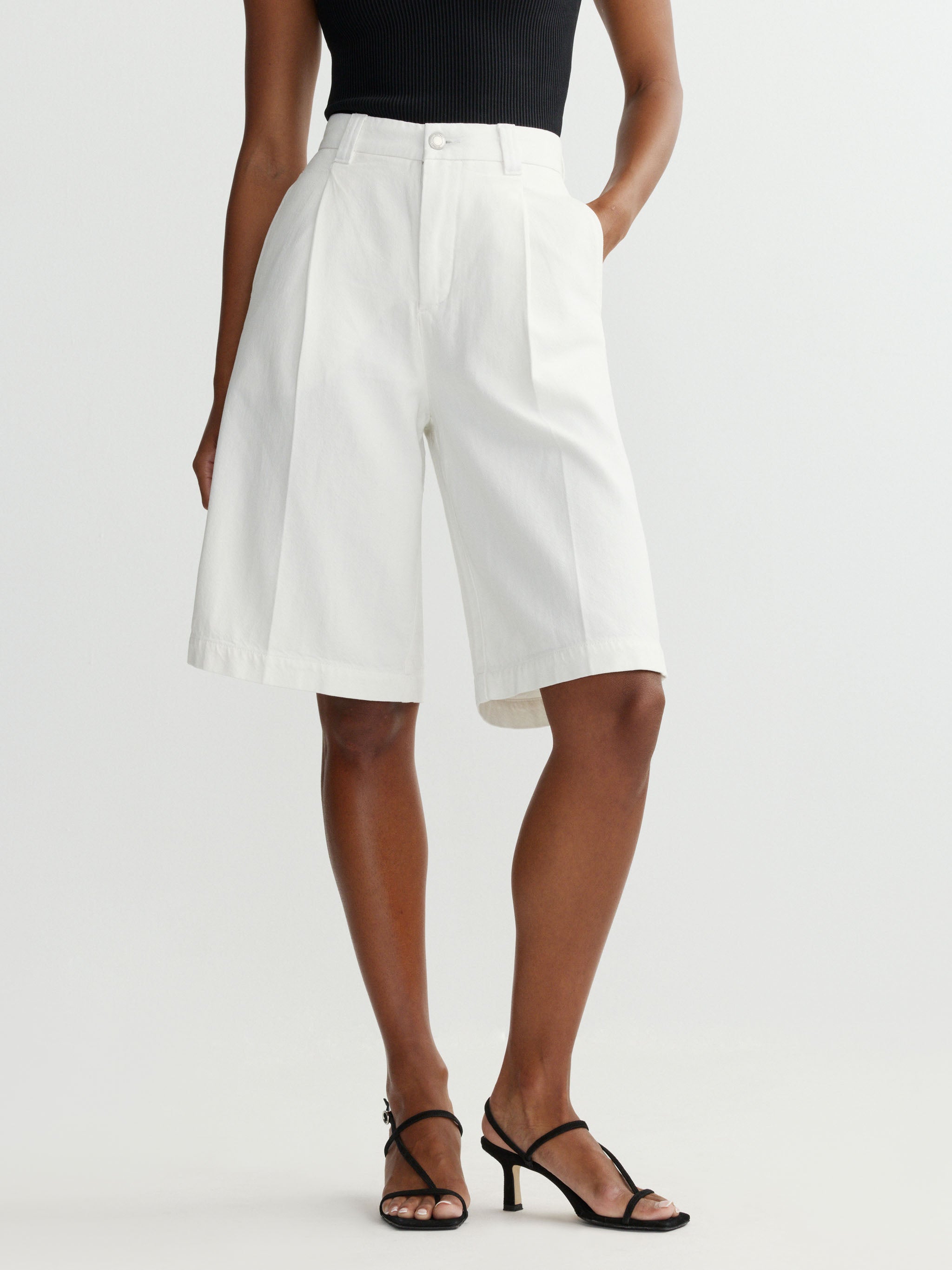 Person wearing white shorts on a plain background