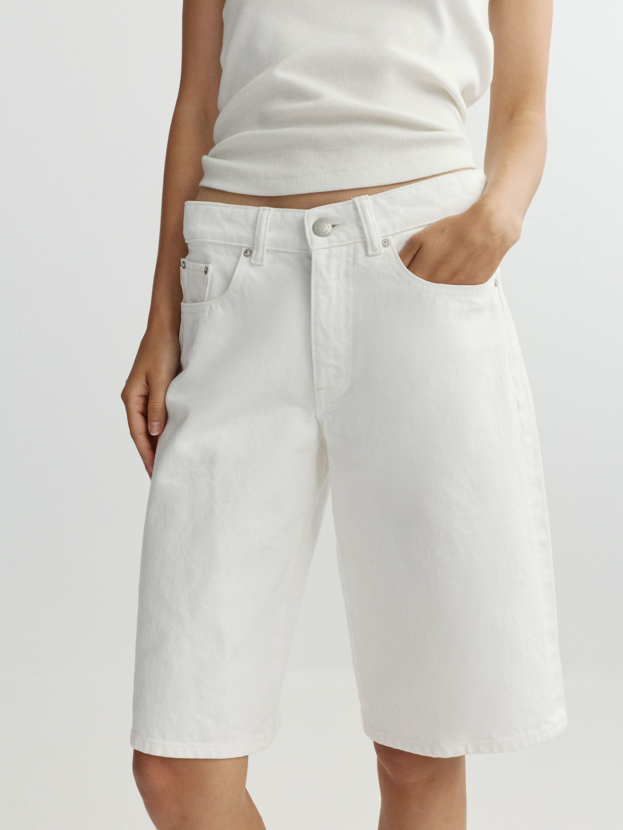 Person wearing white shorts on a plain background