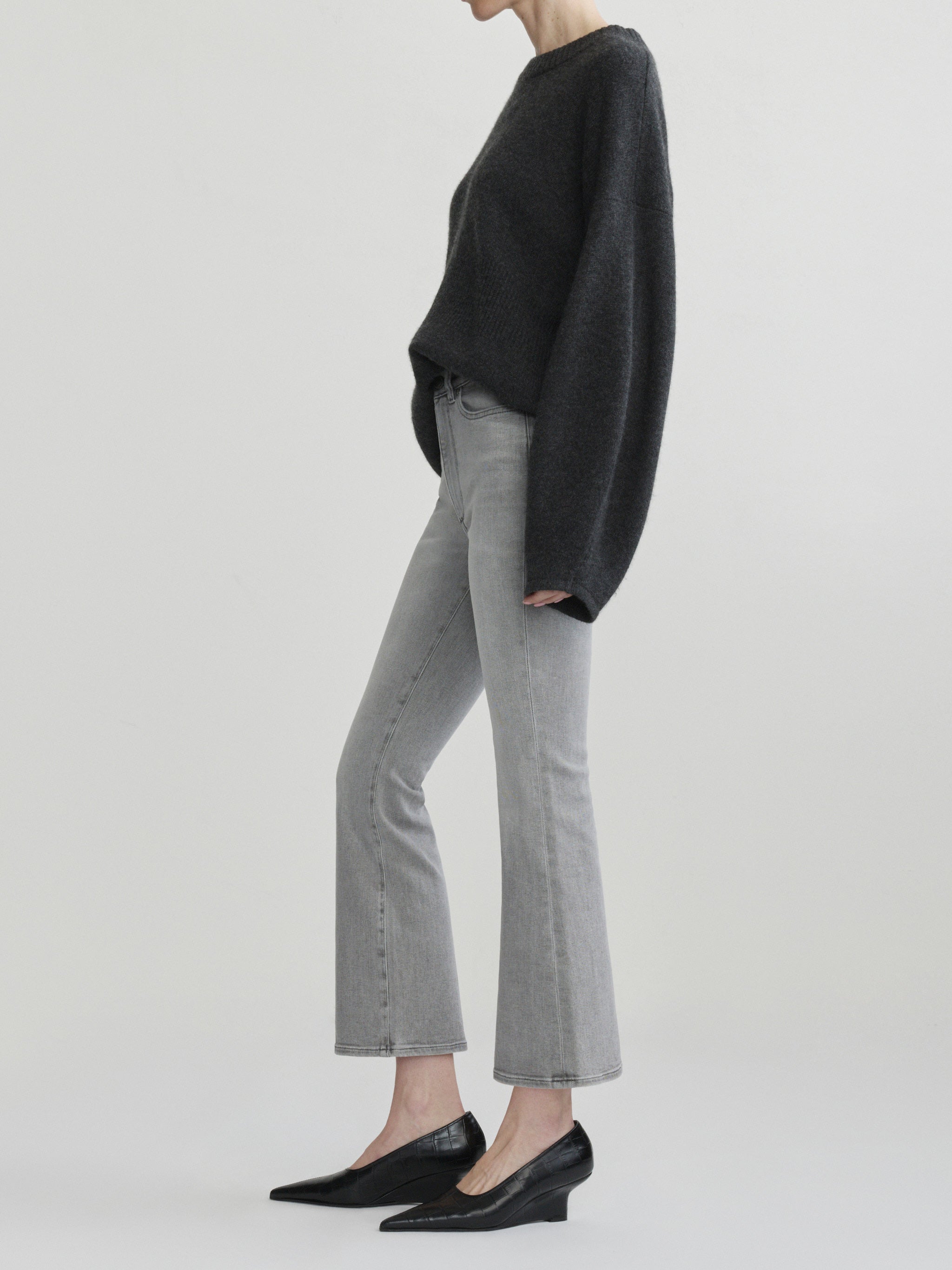 Bridget Boot jeans in Light Smoke on a model with a charcoal sweater, full-length side view, studio.
