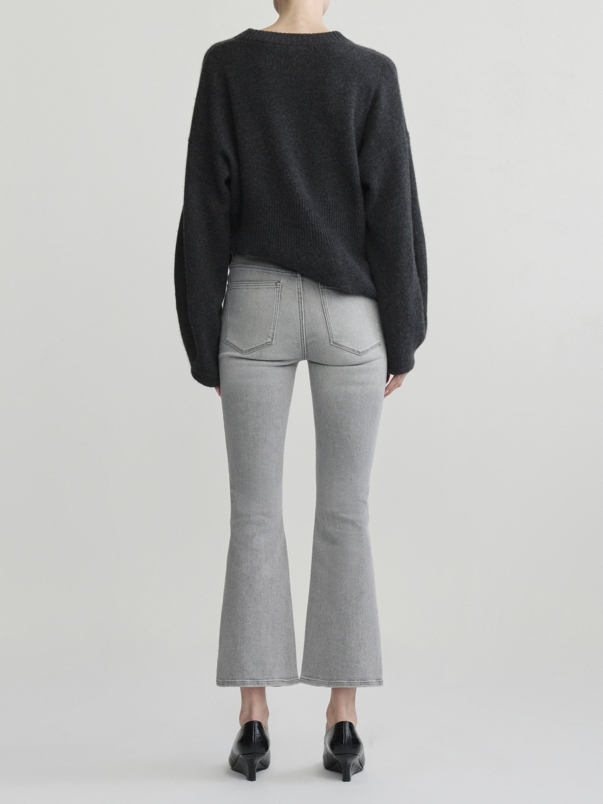 Bridget Boot jeans in Light Smoke on a model with a charcoal sweater, full-length back view, studio.