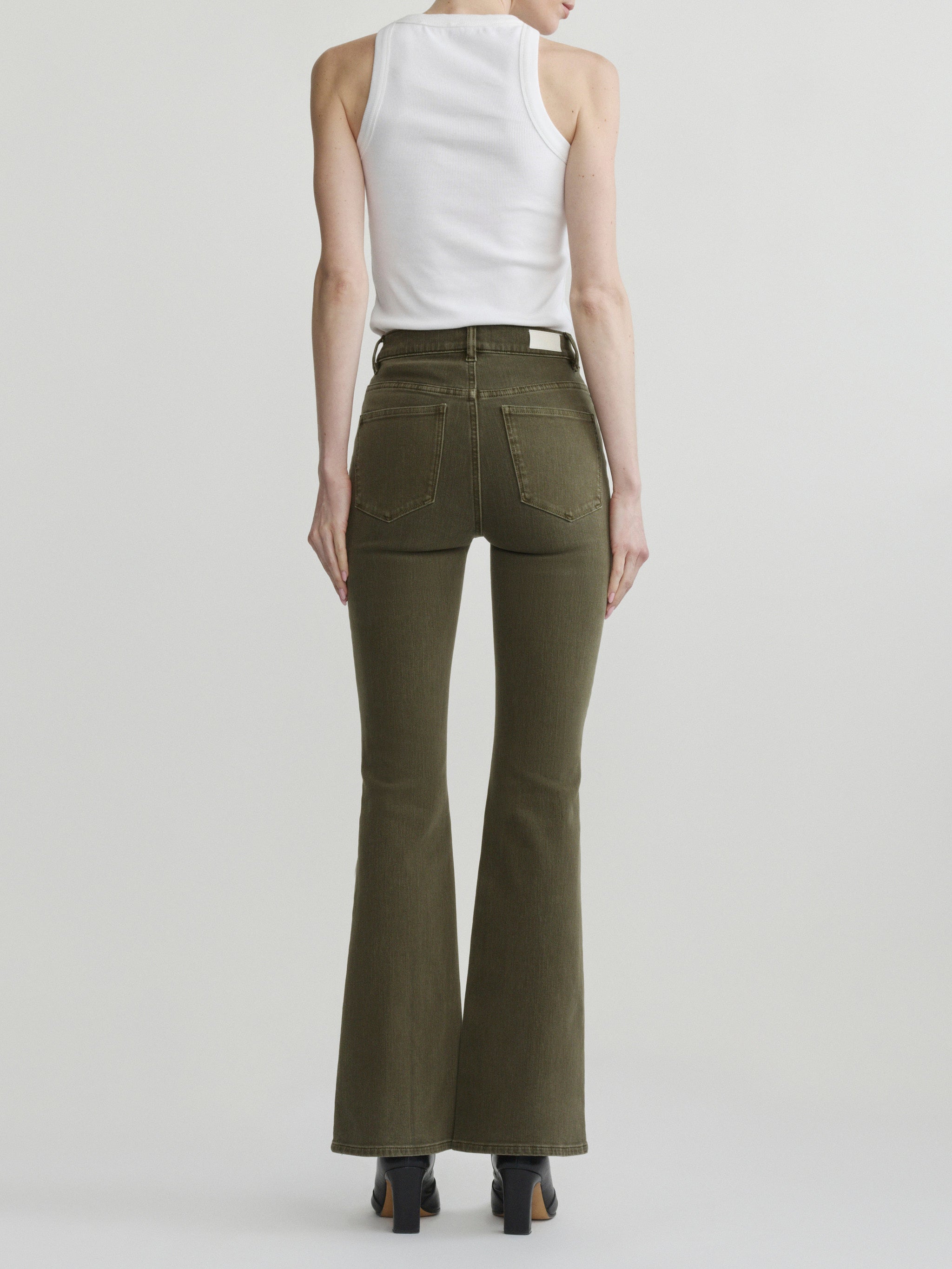 Bridget Boot jeans in Pine on a model with a white tank, full-length back view in a studio.