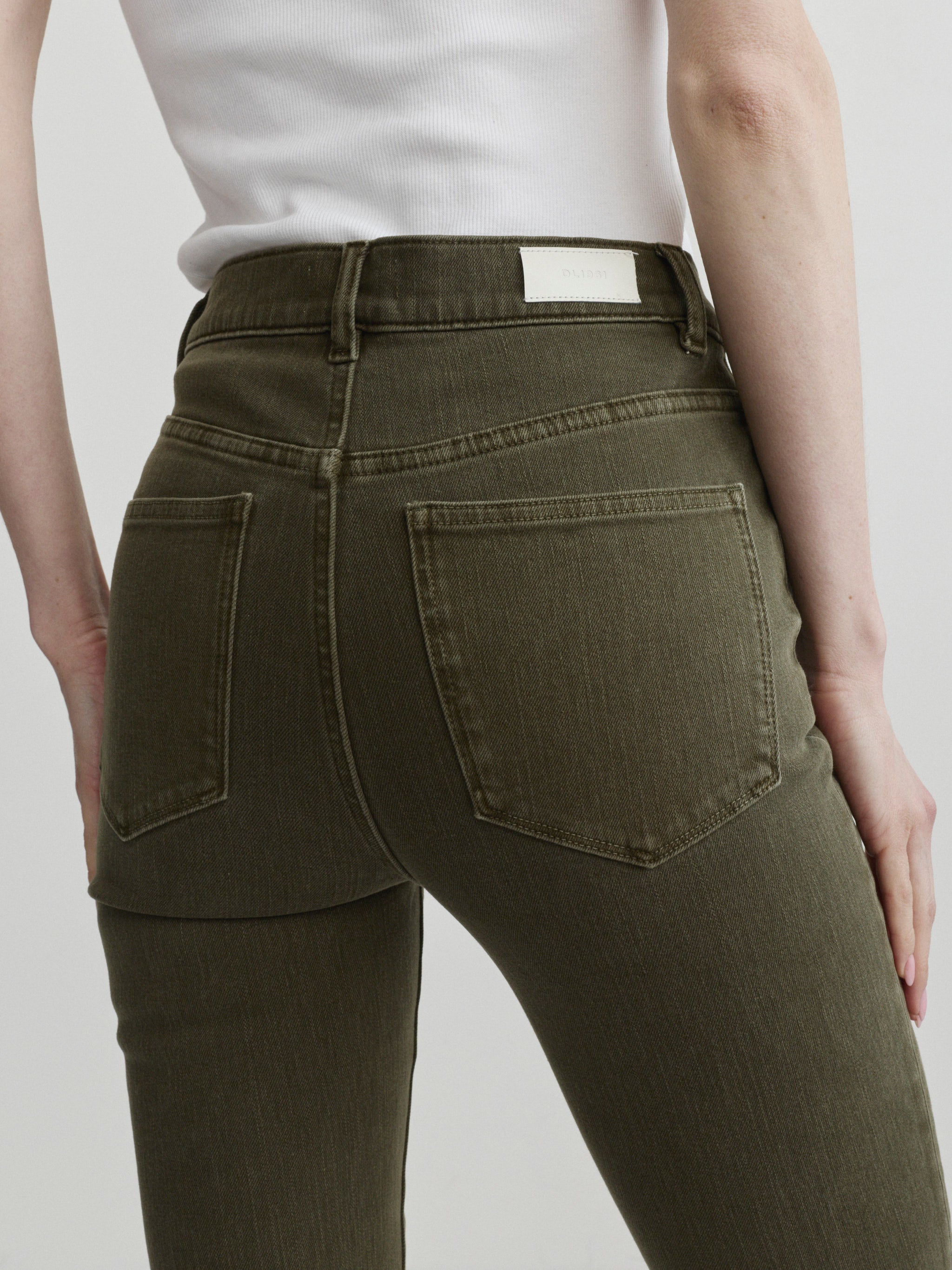 Bridget Boot jeans in Pine styled with the Nara Jacket in December, close-up back view of pockets on a model.