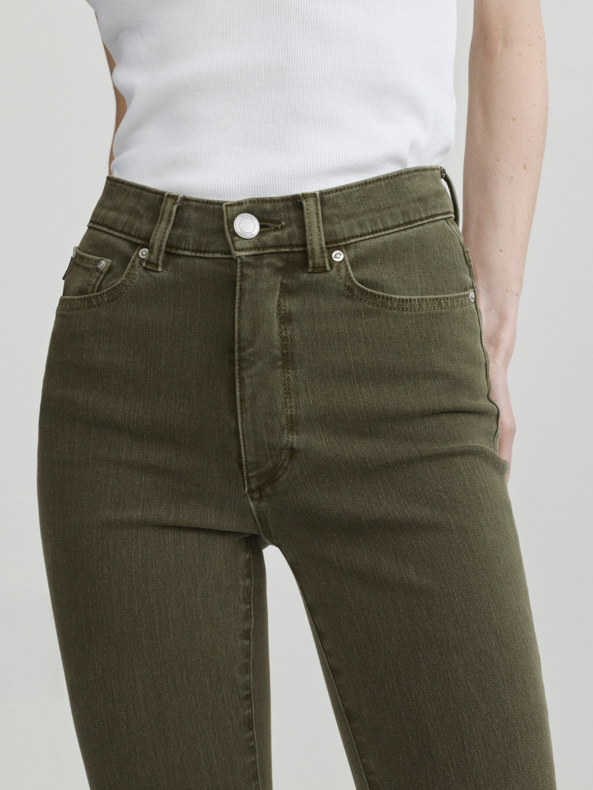 Bridget Boot jeans in Pine styled with the Nara Jacket in December, close-up front view of waist on a model.