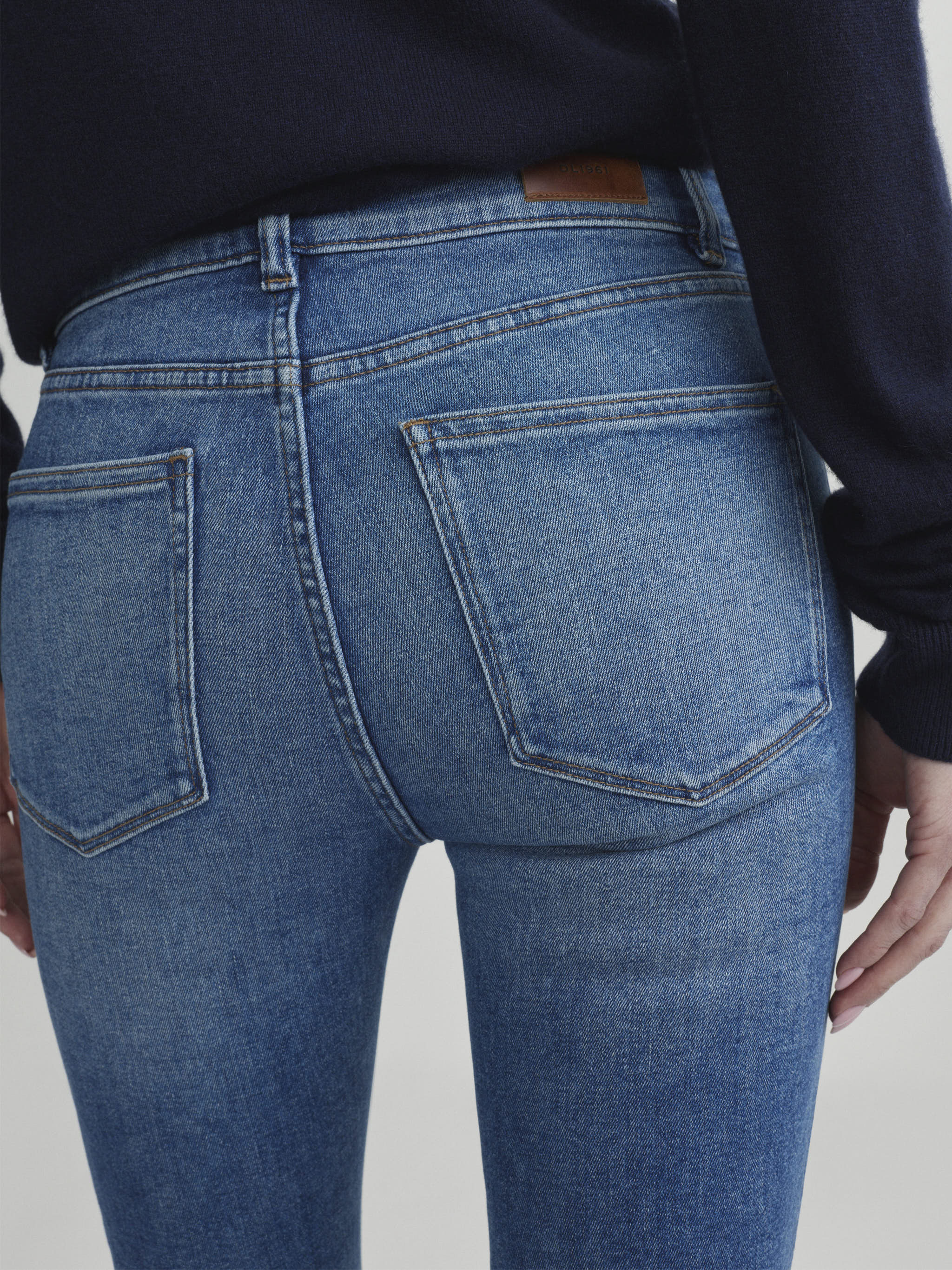 Mara Straight jeans in Crisp Air on a model, close-up back view of pockets in studio.