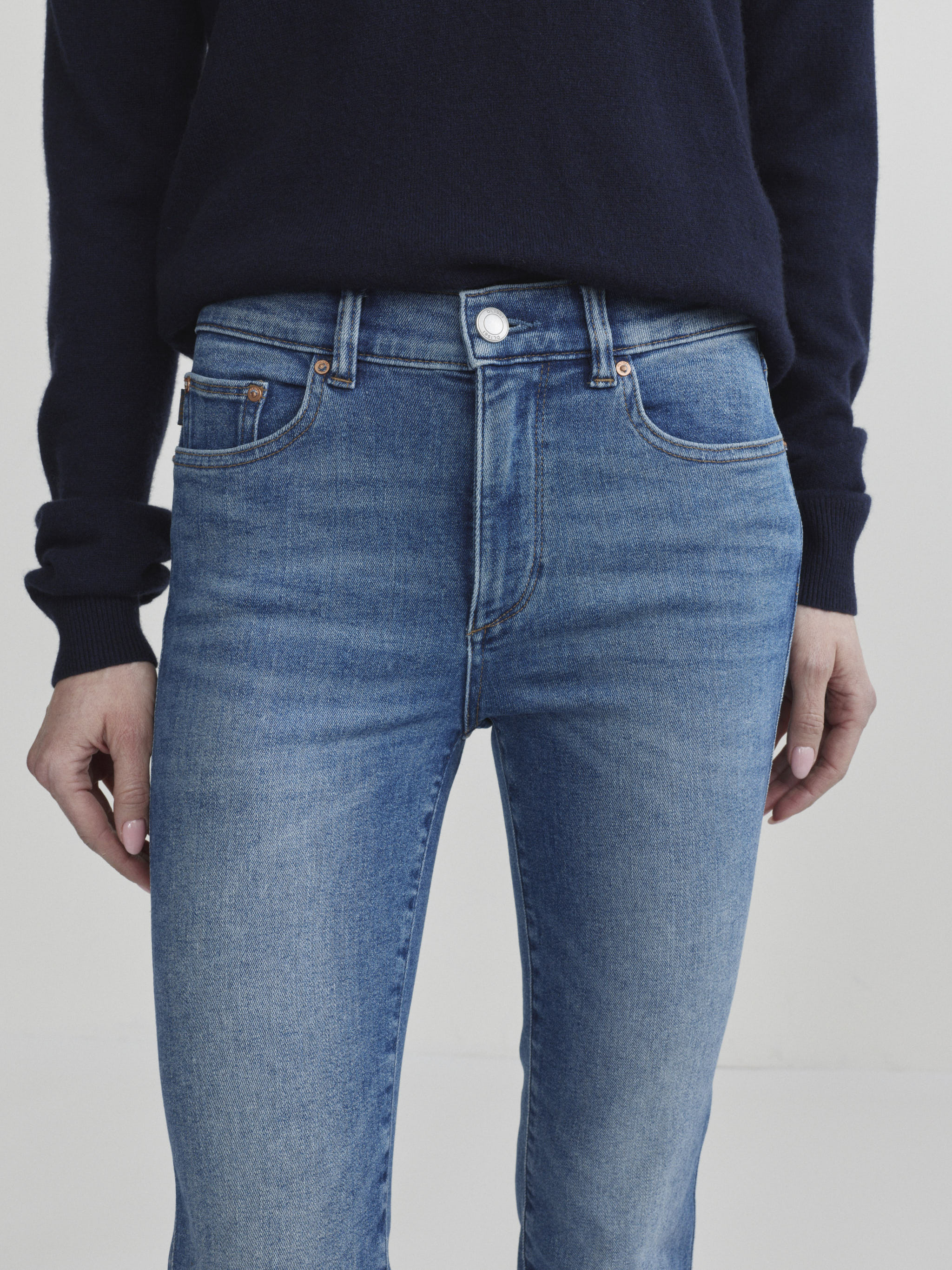 Mara Straight jeans in Crisp Air on a model, close-up front view of waist and fly in studio.
