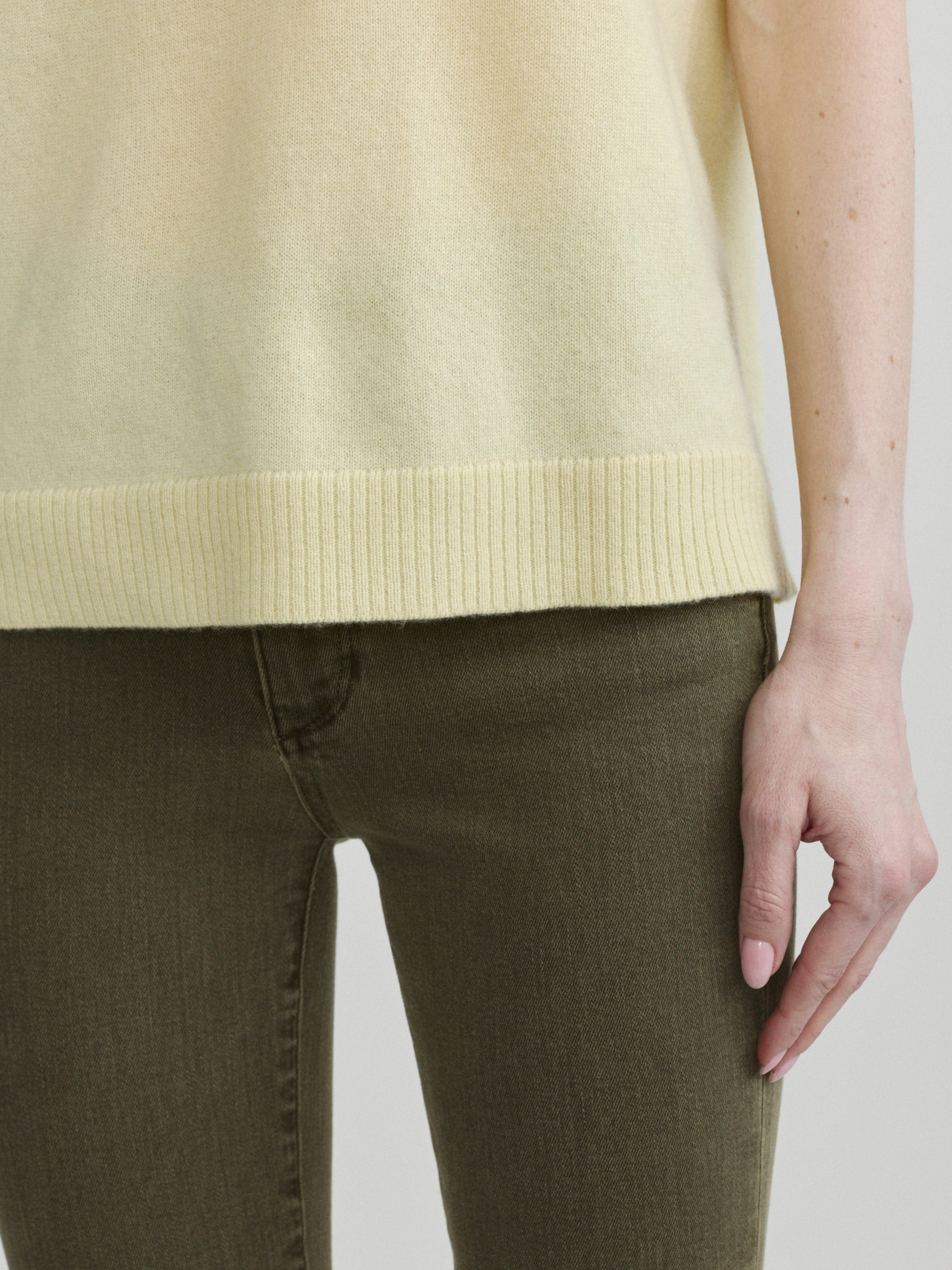 Mara Straight jeans in Pine with Knit Tee in Moonlight on a model, close-up of hem of tee and waist.