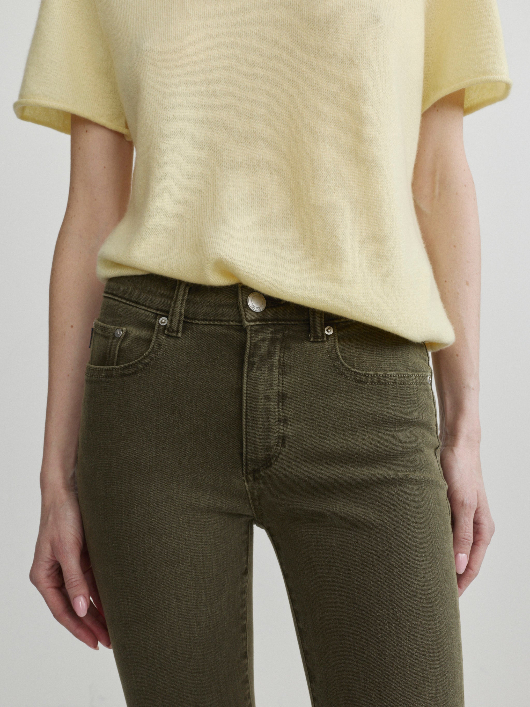 Mara Straight jeans in Pine with Knit Tee in Moonlight on a model, close-up front view of waist.