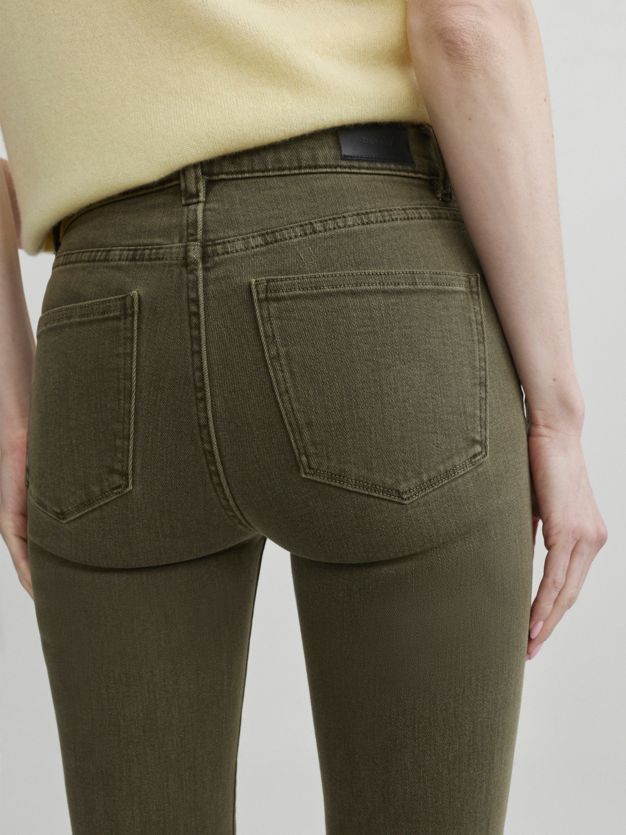 Mara Straight jeans in Pine with Knit Tee in Moonlight on a model, close-up back view of pockets.
