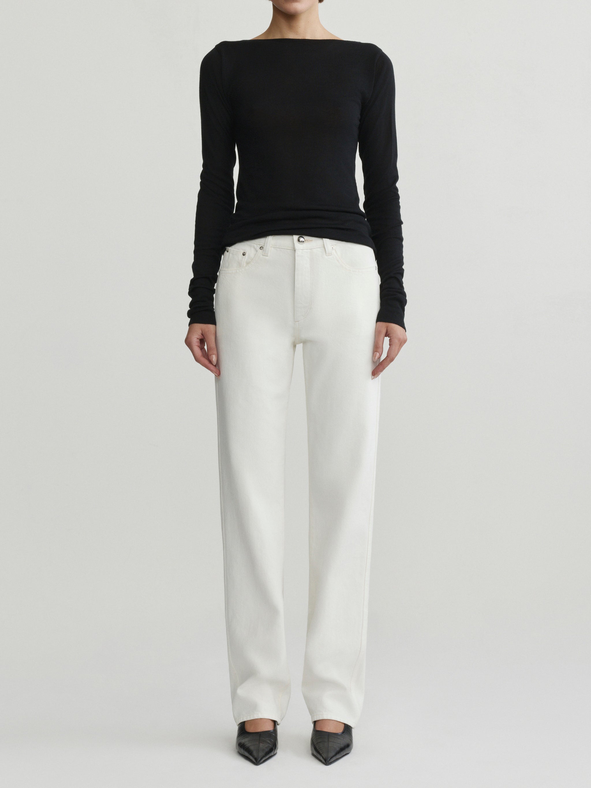 Cate Slim Leg jeans in Eggshell with black top on a model, full-length front view in studio.