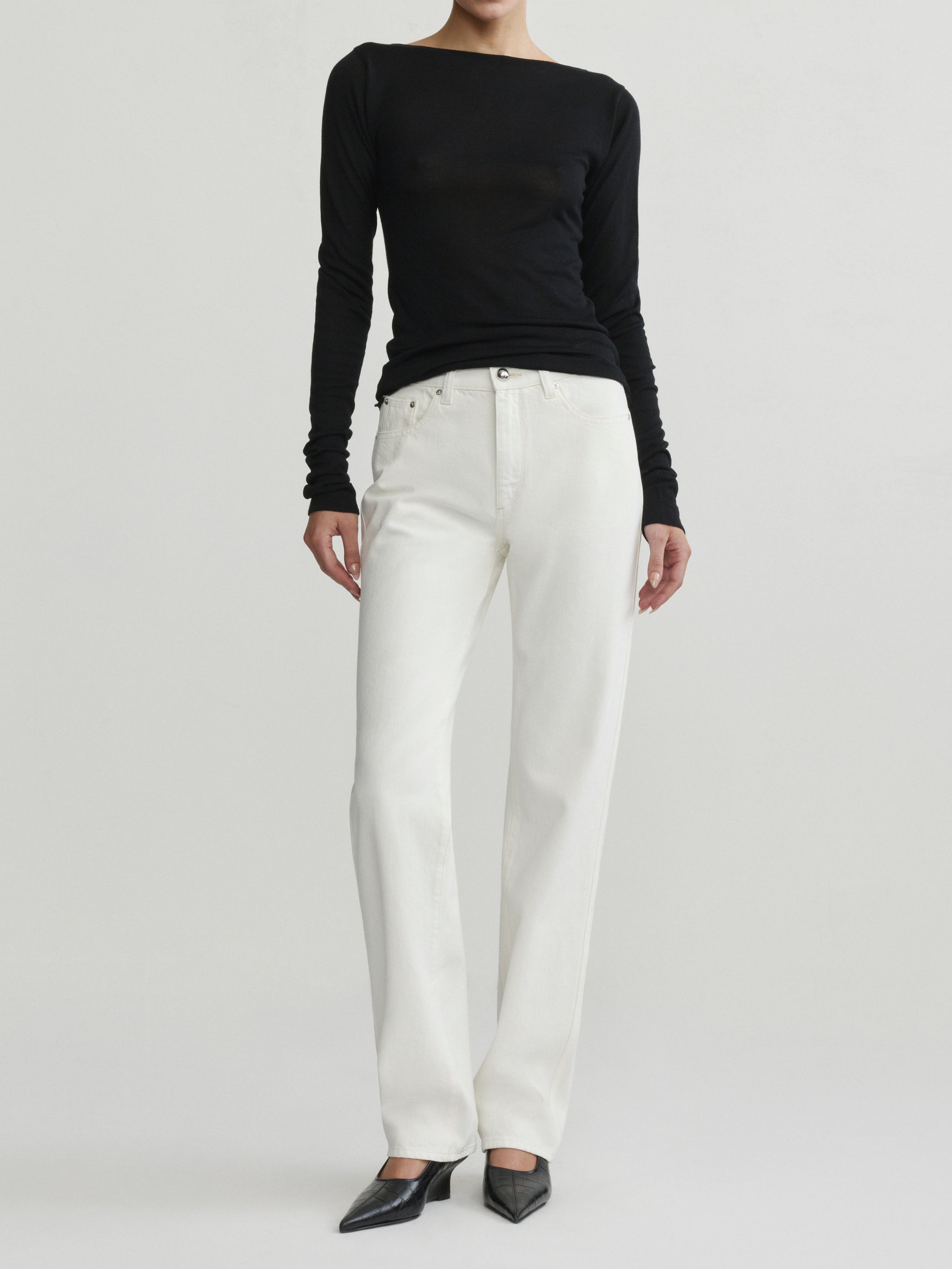 Cate Slim Leg jeans in Eggshell with black top on a model, full-length front view in studio.