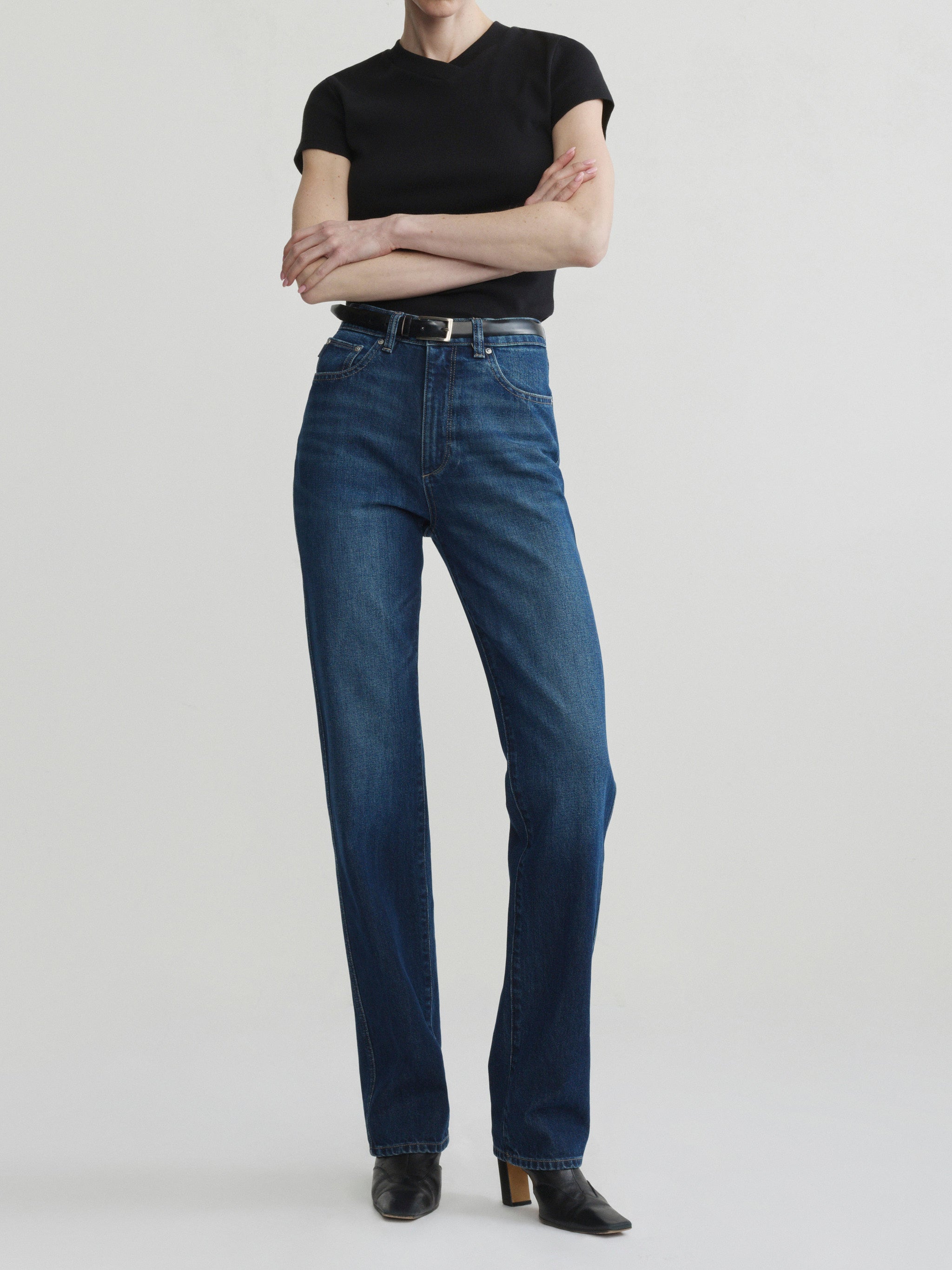 Cate Slim jeans in December with black tee on a model, full-length front view, arms crossed.