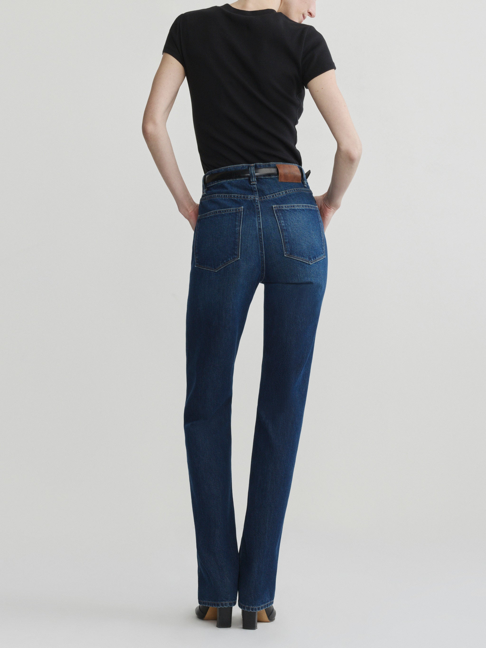 Cate Slim jeans in December on a model with black tee, full-length back view in a studio.