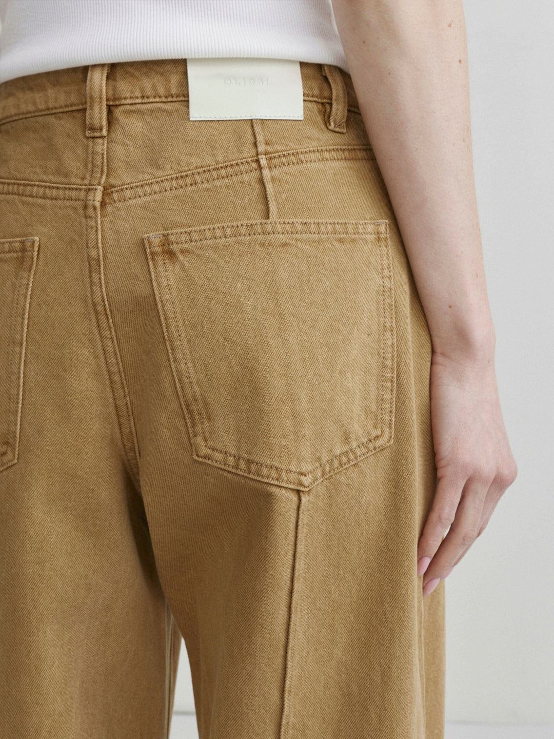 Kaylen Soft Curve jeans in Savannas with a white tank top, close-up of back pocket.