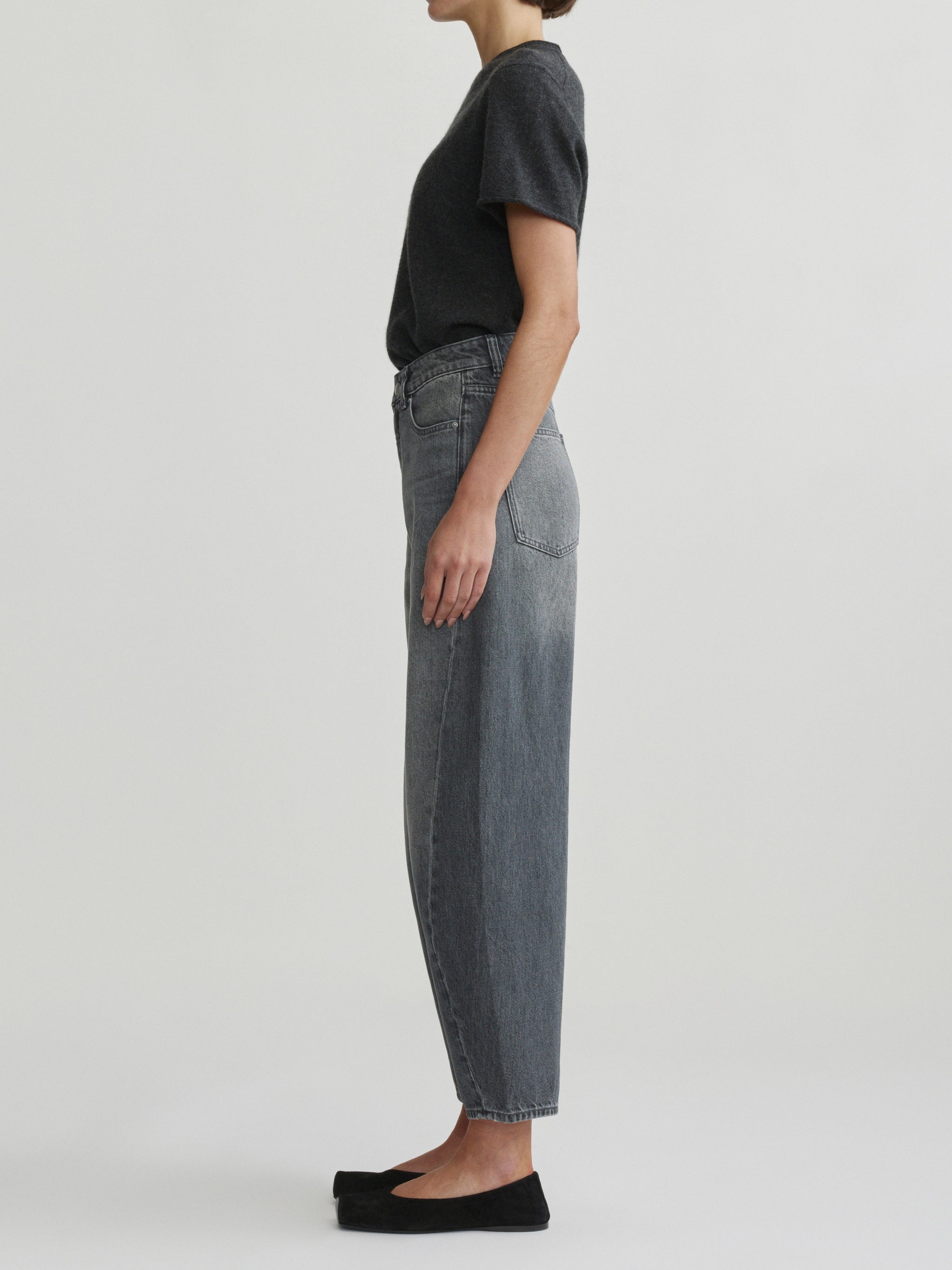 Miro Barrel jeans in Ash Grey on a model with charcoal tee, side view in studio.