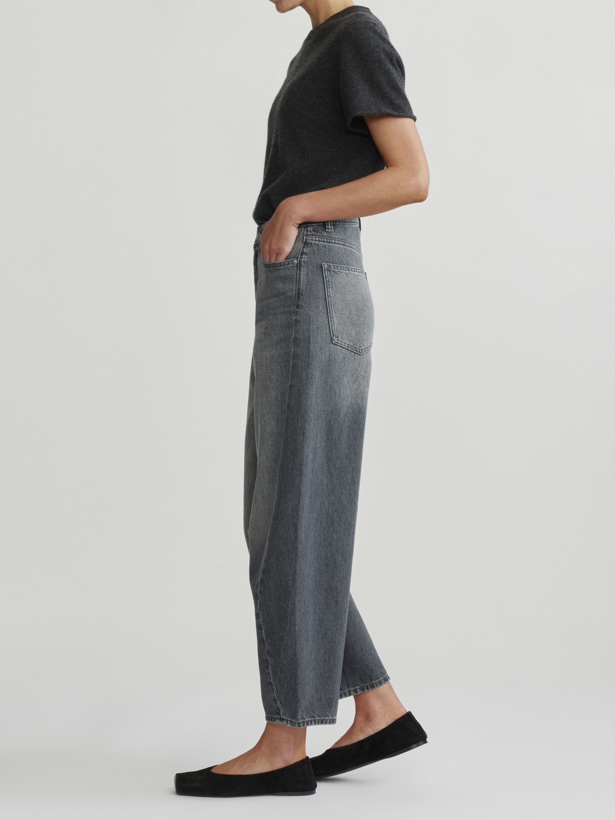 Miro Barrel jeans in Ash Grey on a model with charcoal tee, three-quarter side view in studio.