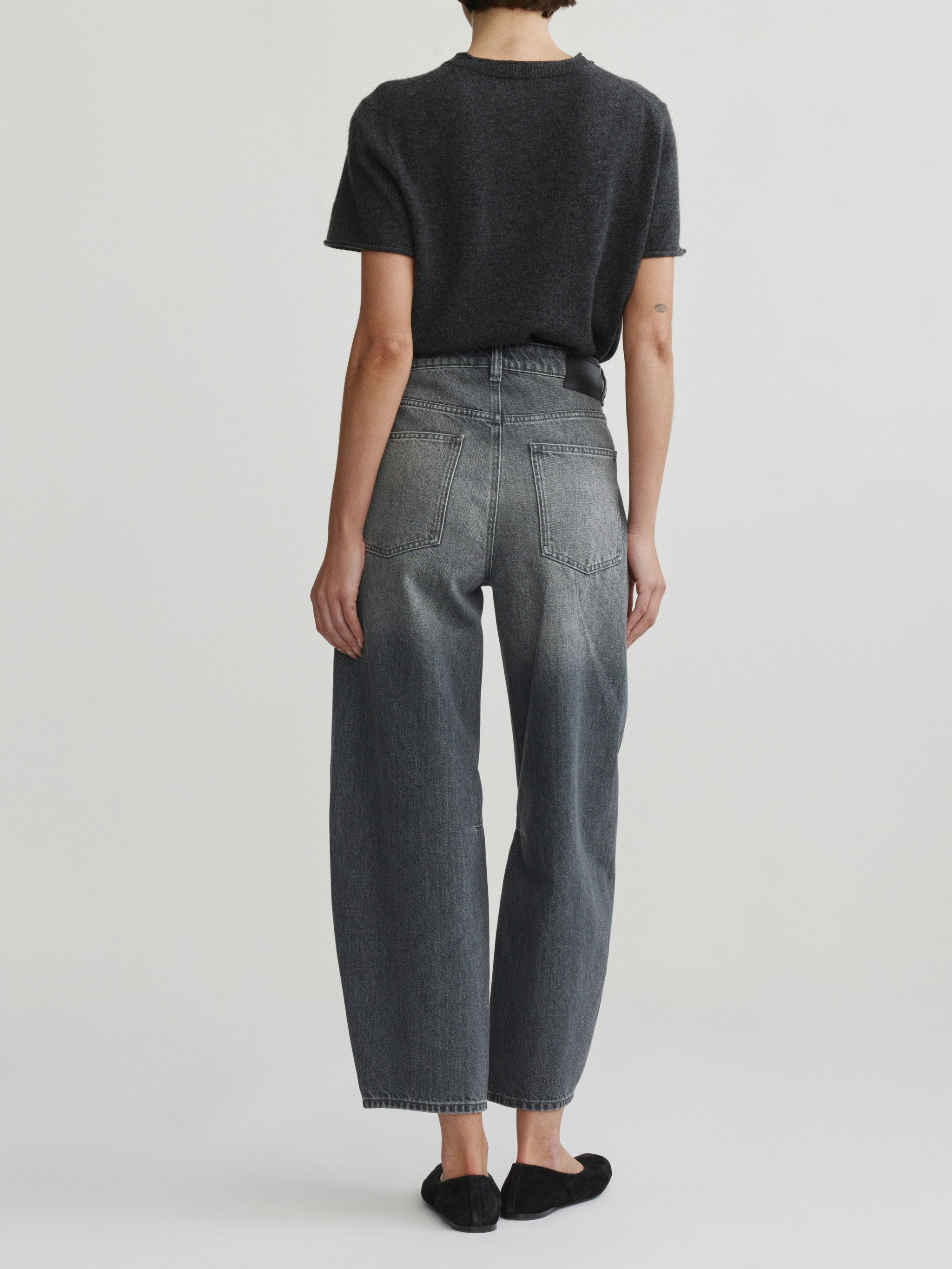 Miro Barrel jeans in Ash Grey on a model with dark tee, three-quarter back view in studio.