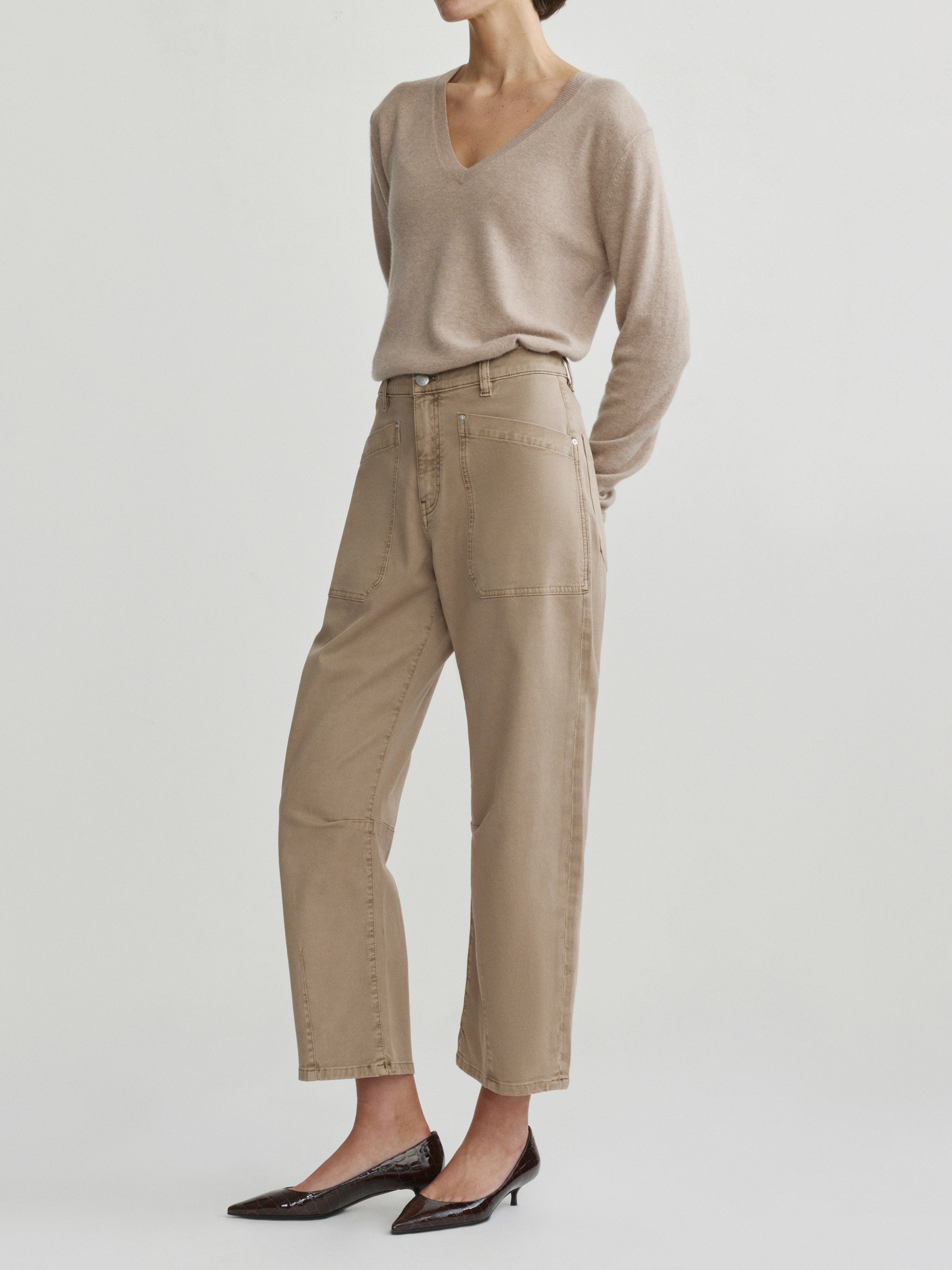 Bilie Easy Barrel jeans in Desert on a model with beige sweater, side view in studio.