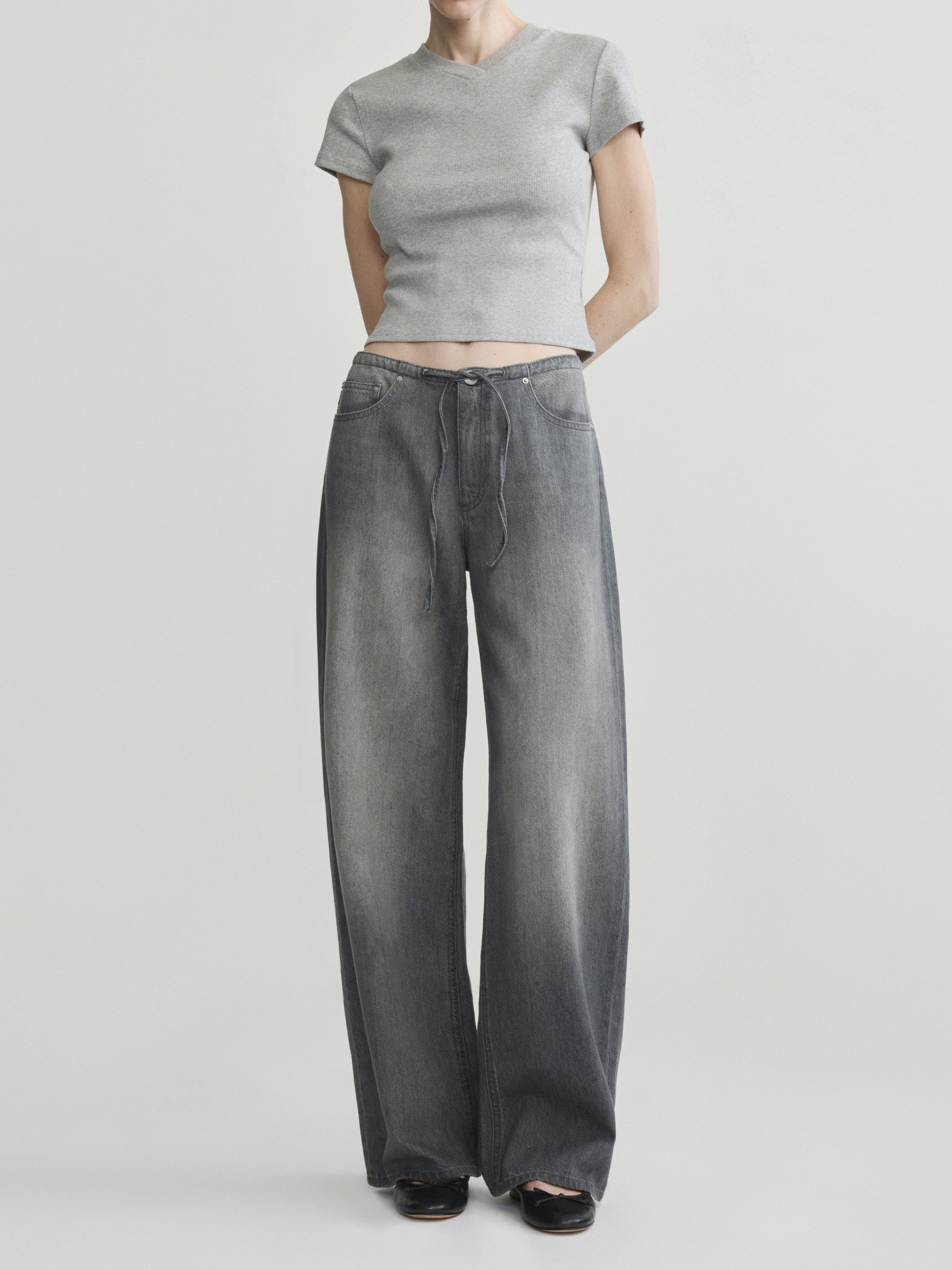 Sienna Low-Slung Wide Leg jeans in Ash Grey Aura on a model with grey tee, three-quarter front view.