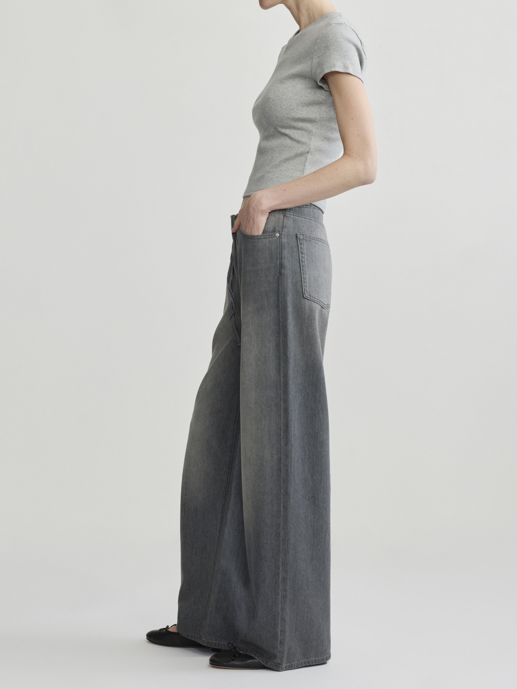 Sienna Low-Slung Wide Leg jeans in Ash Grey Aura on a model with grey tee, side view in studio.