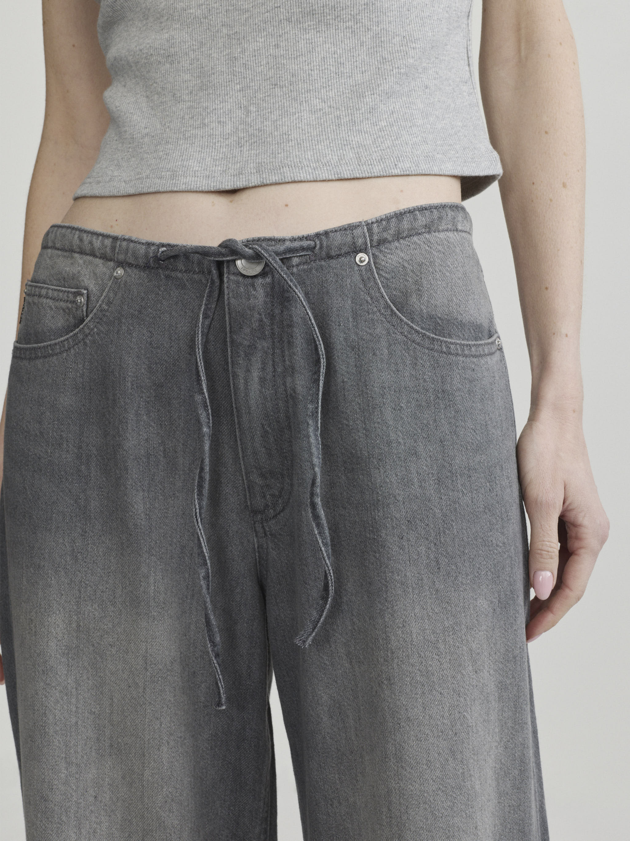 Sienna Low-Slung Wide Leg jeans in Ash Grey Aura on a model, close-up front view of drawstring waist.