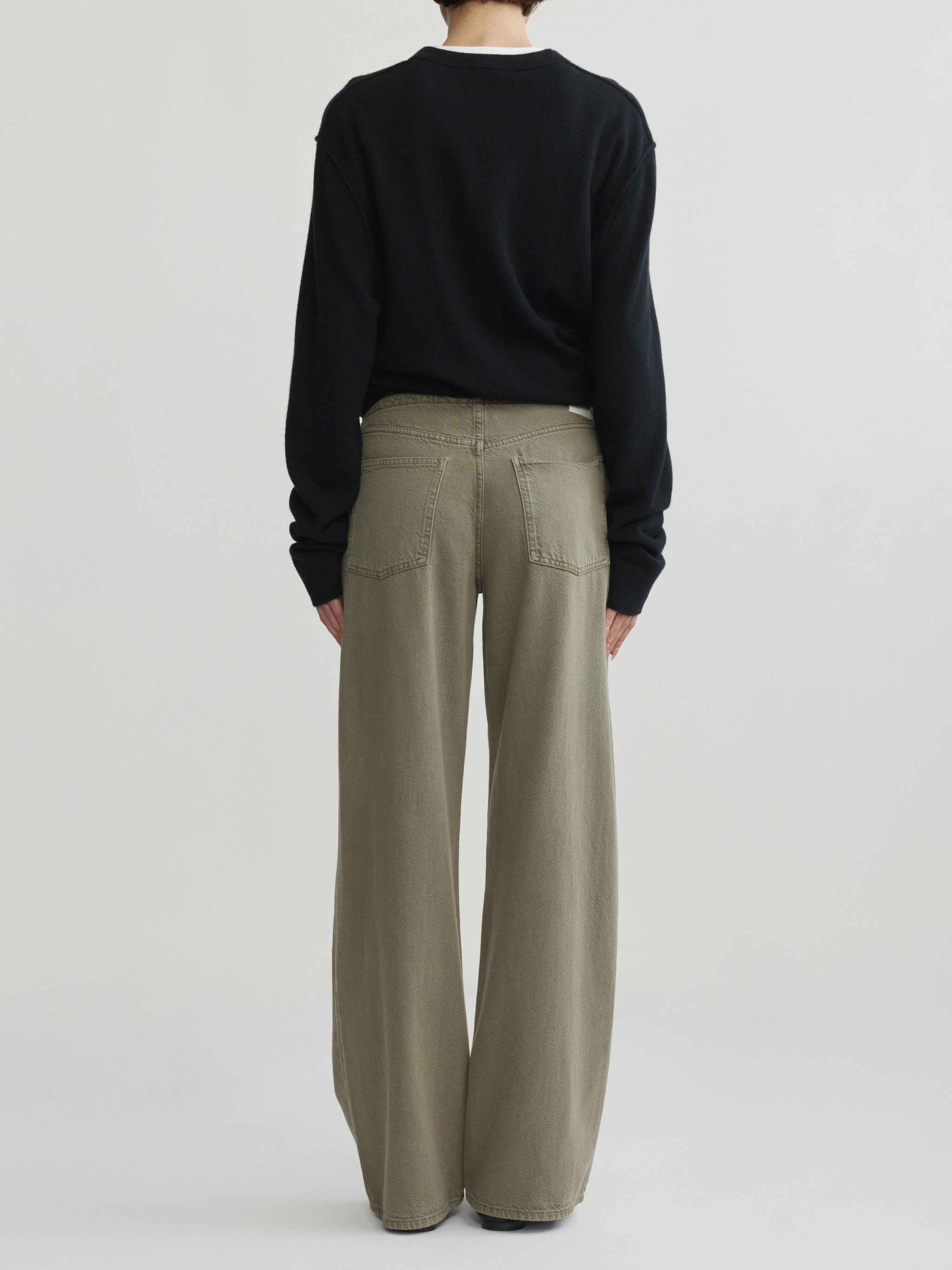 Sienna Low-Slung Wide Leg jeans in Clover Aura on a model in black sweater, full-length back view.