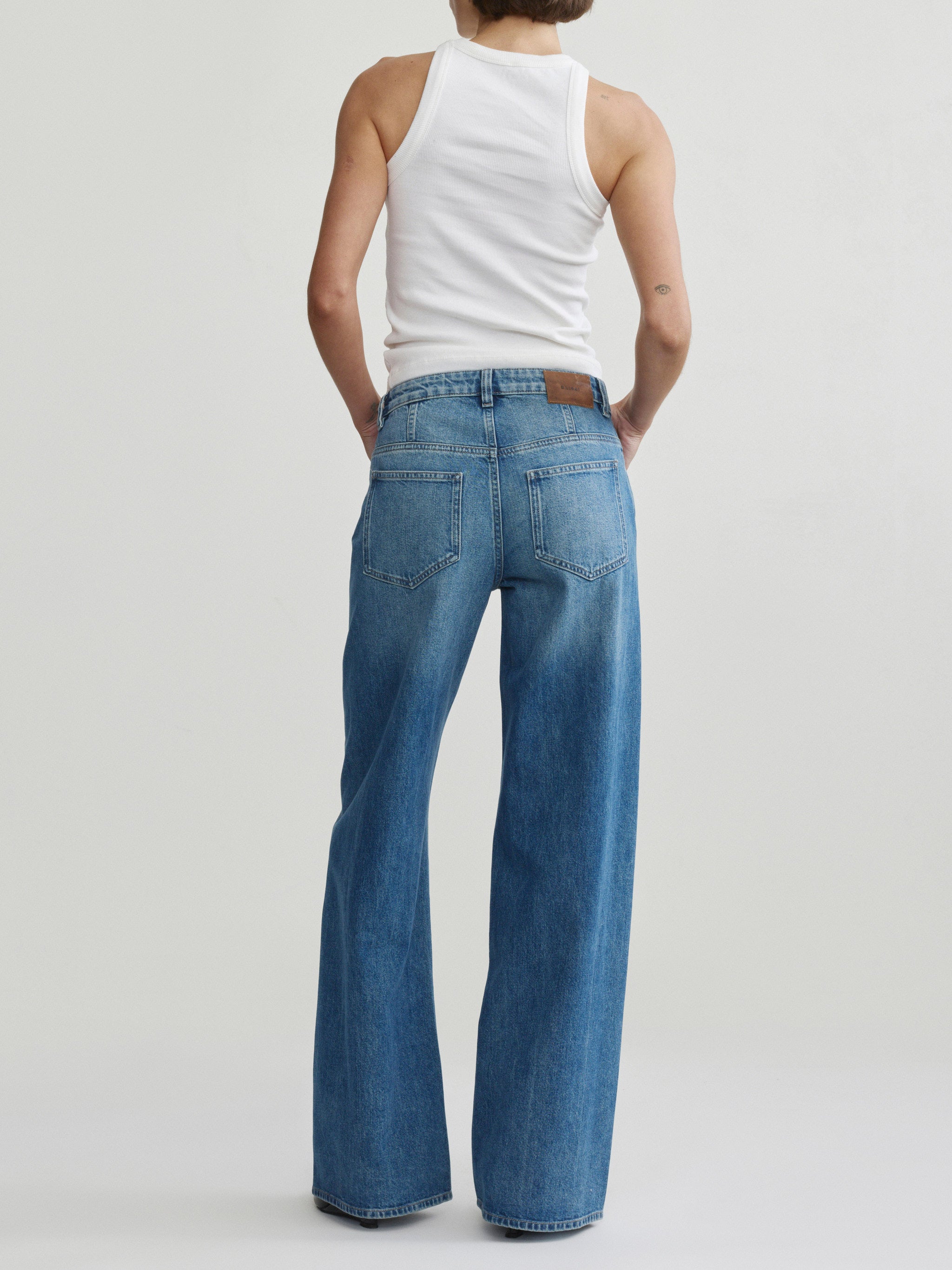 Alex Baggy Wide Leg jeans in Authentic on a model in white tank top, full-length back view.