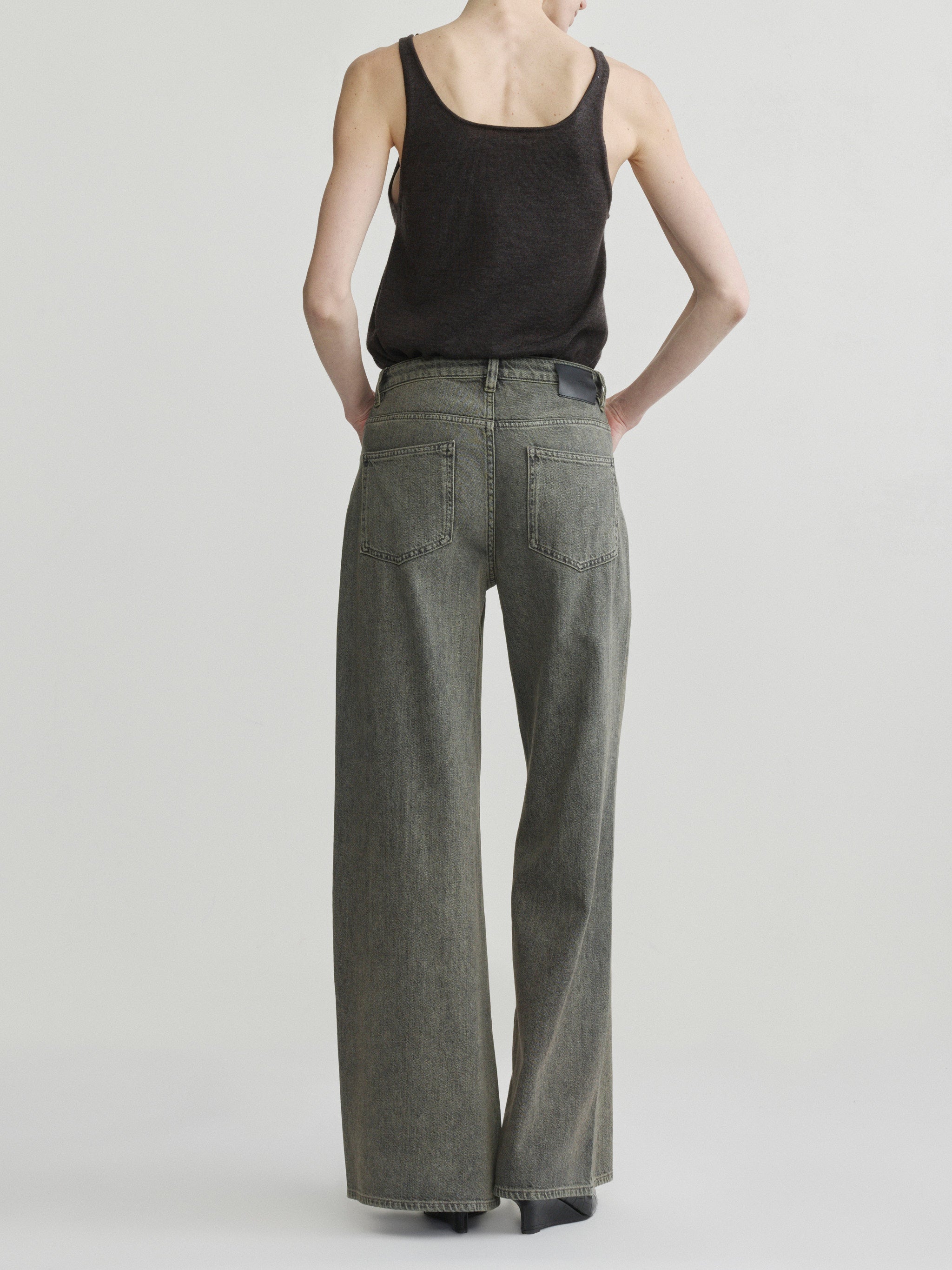 Alex Baggy Wide Leg jeans in Character Green Aura on a model in black tank top, full-length back view.