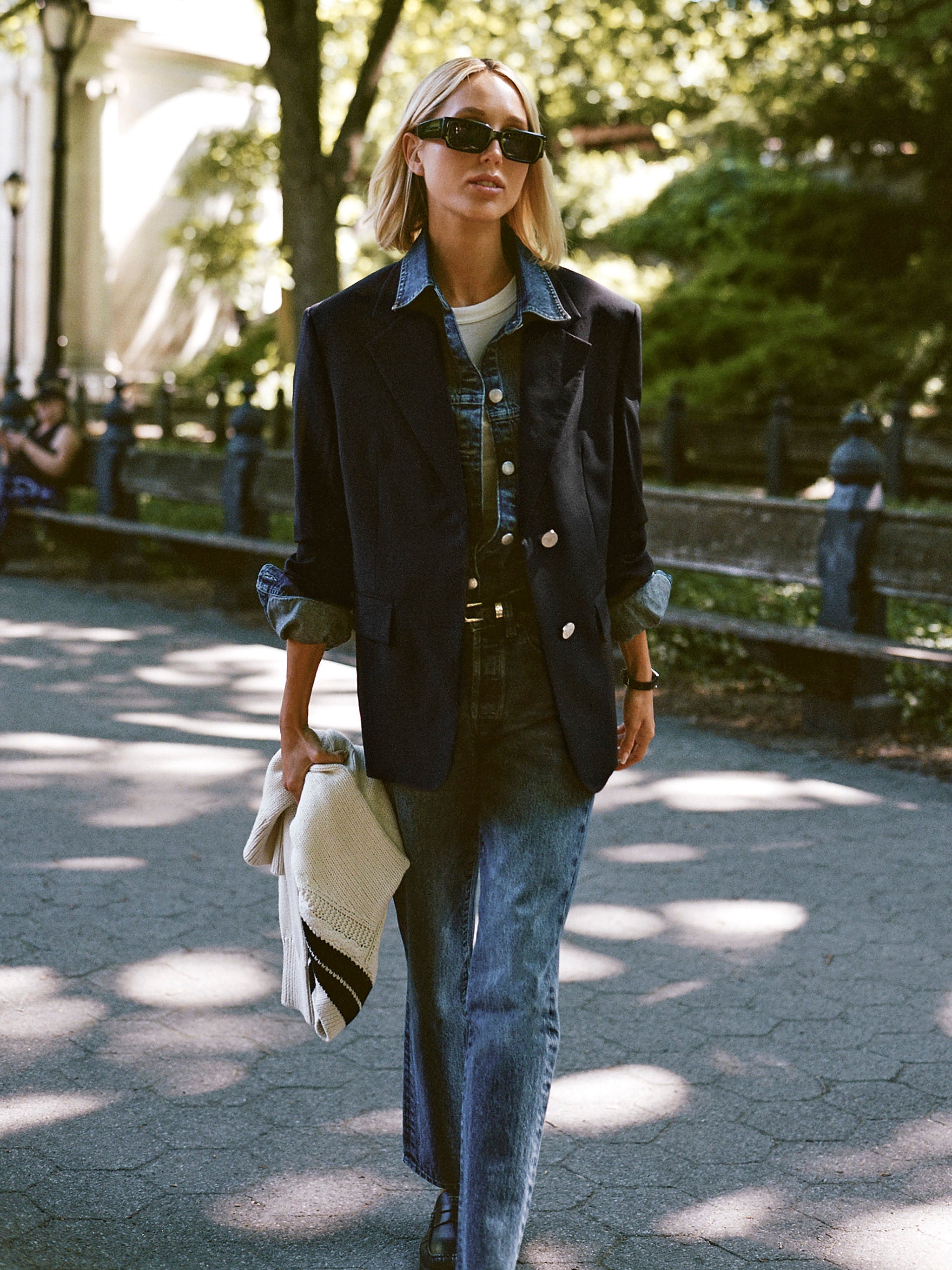 DL1961 x Olympia Slim Straight Jeans in Royal — campaign shot, worn with the matching Addison Overshirt under a black blazer, walking in Central Park
