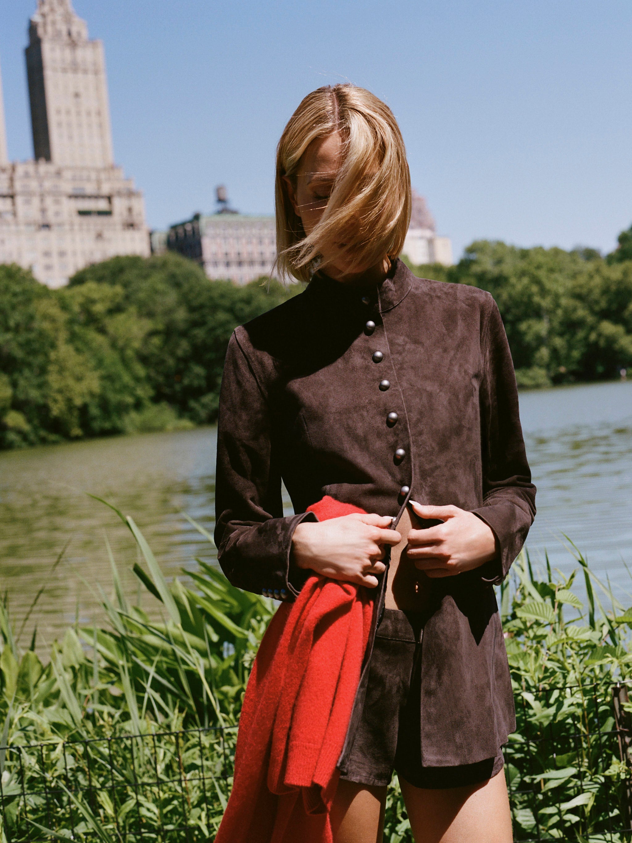 DL1961 x Olympia Maria Suede Jacket in Tobacco Suede — cropped campaign shot, model fastening the front snap placket