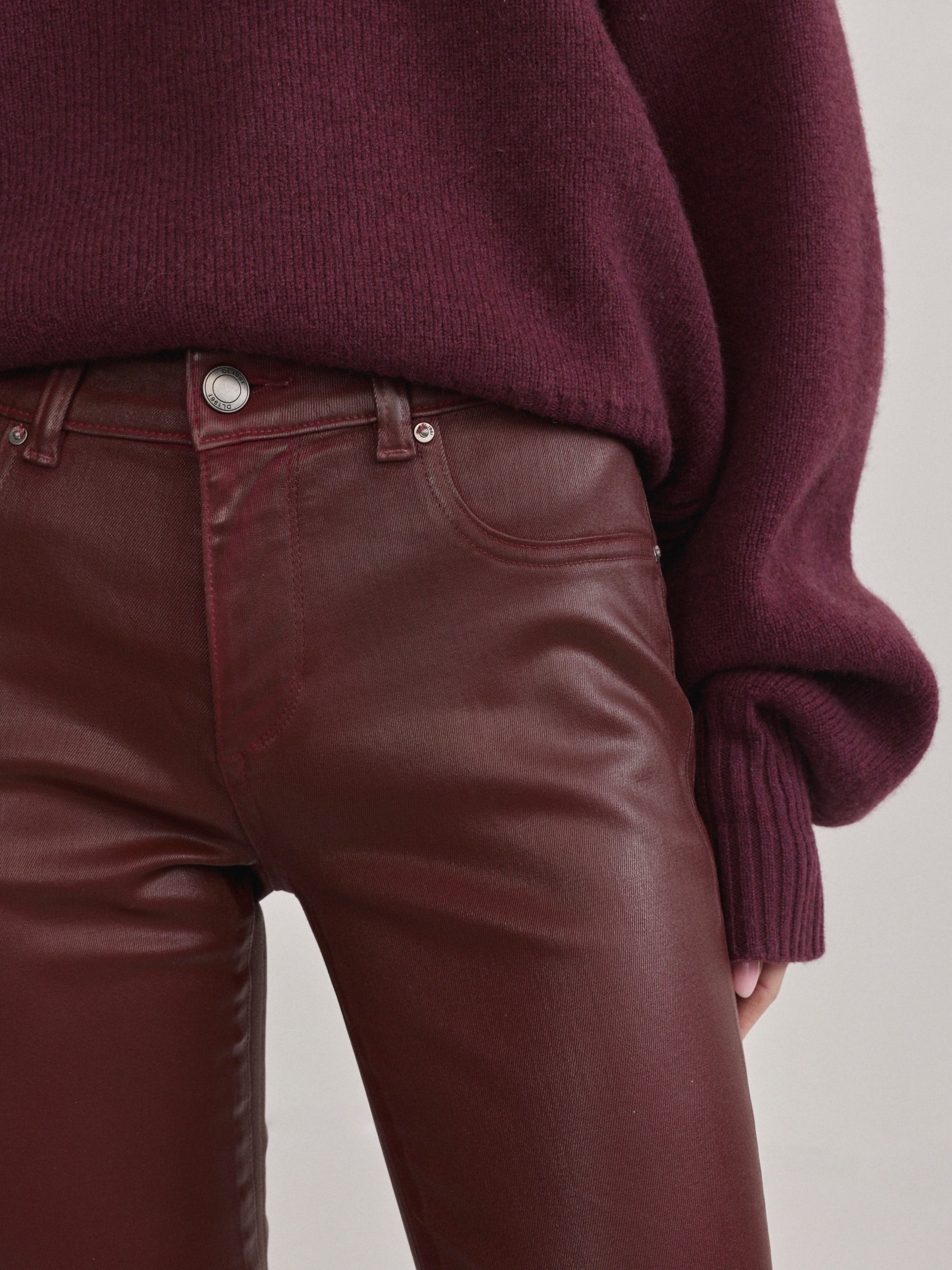 DL1961 Jessica Skinny Low-Rise coated jeans in Burgundy Coated, close-up of button and pockets.