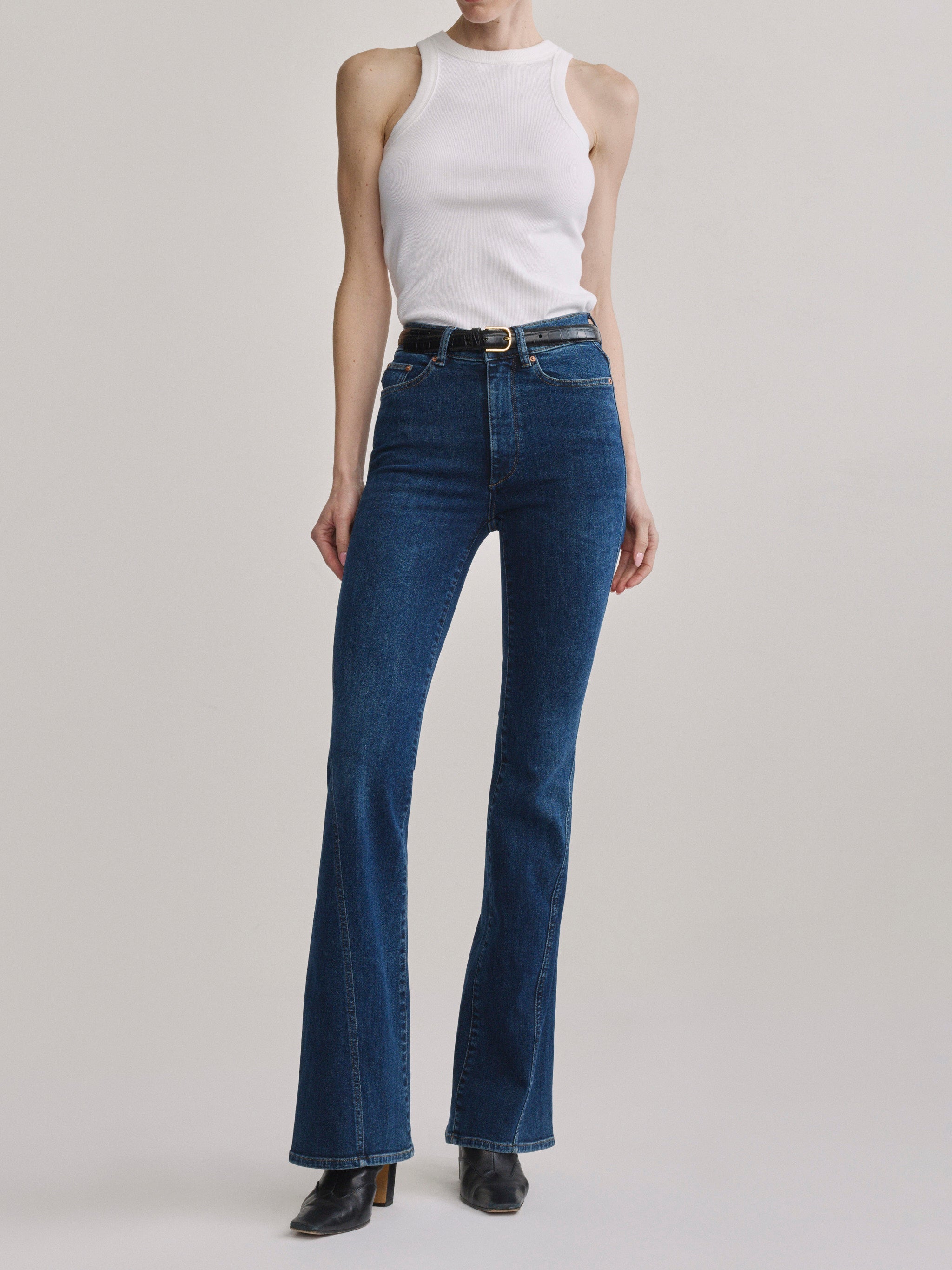 Bridget Boot Breeze Seamed jeans with the High Neck Ribbed Tank in White and a belt, full-length front view.