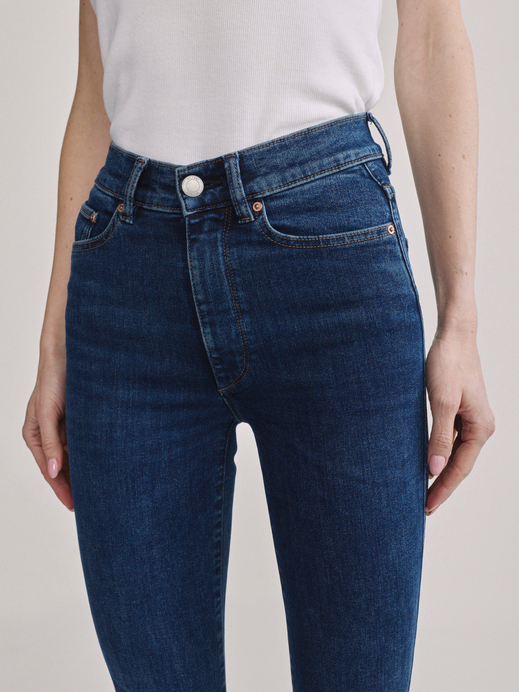 Bridget Boot Breeze Seamed jeans, close-up front view of the high-rise waist and pocket on a model.