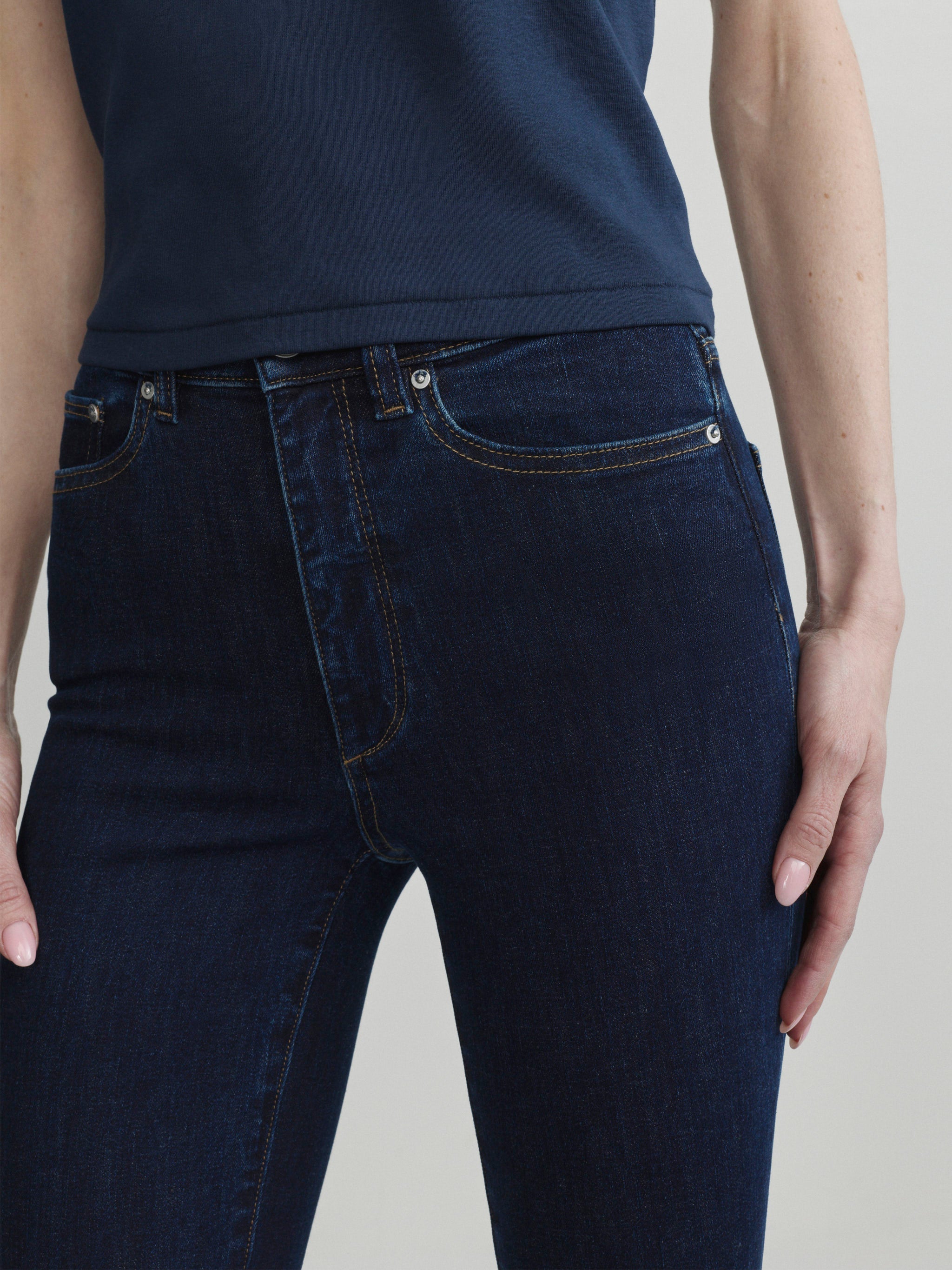 Bridget Boot jeans in Night Out with Navy tee, close-up of front waistband and pocket detail.