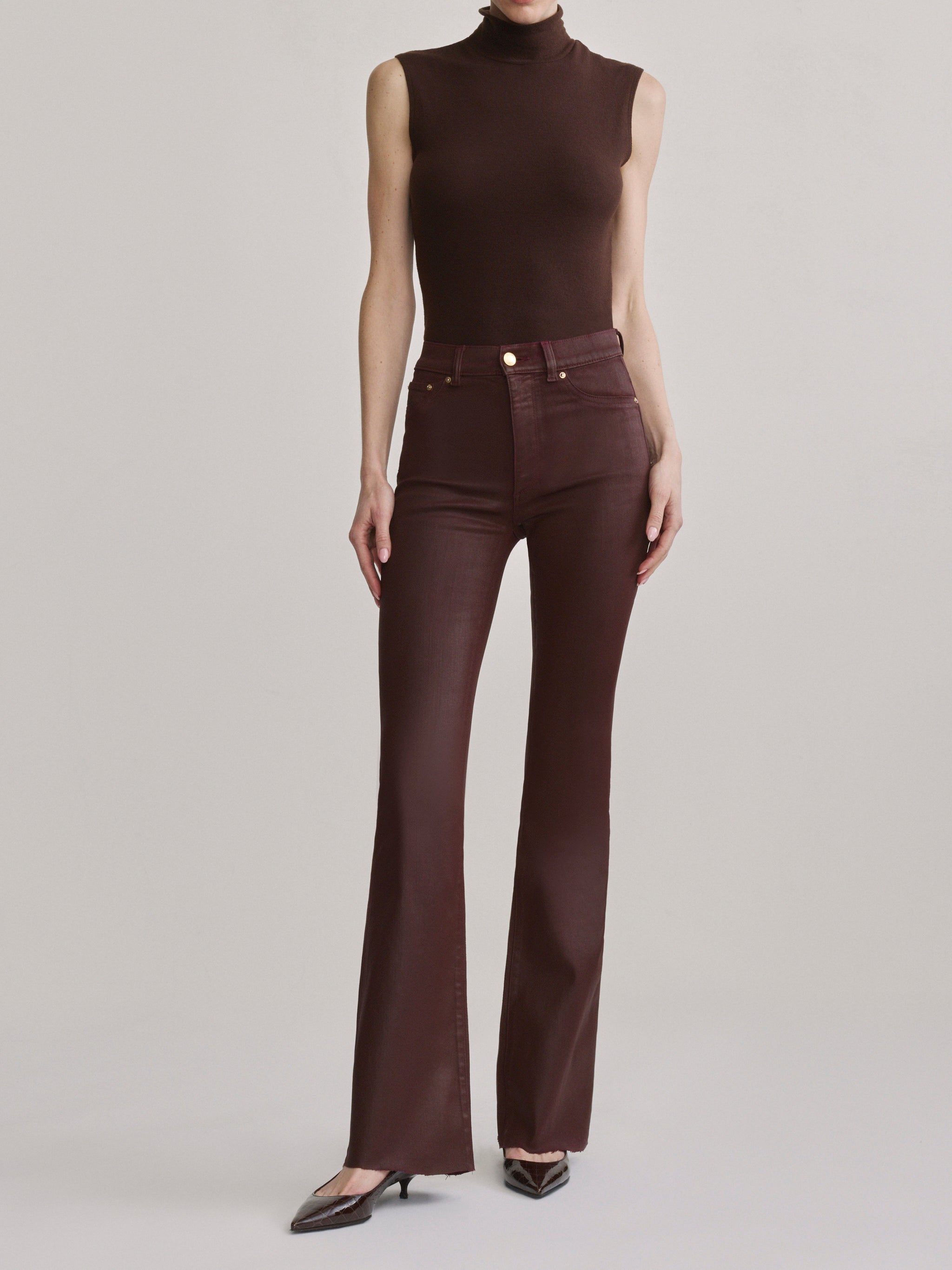 DL1961 Bridget bootcut high-rise jeans in glossy burgundy 'Vin Rouge Coated', front view with turtleneck.