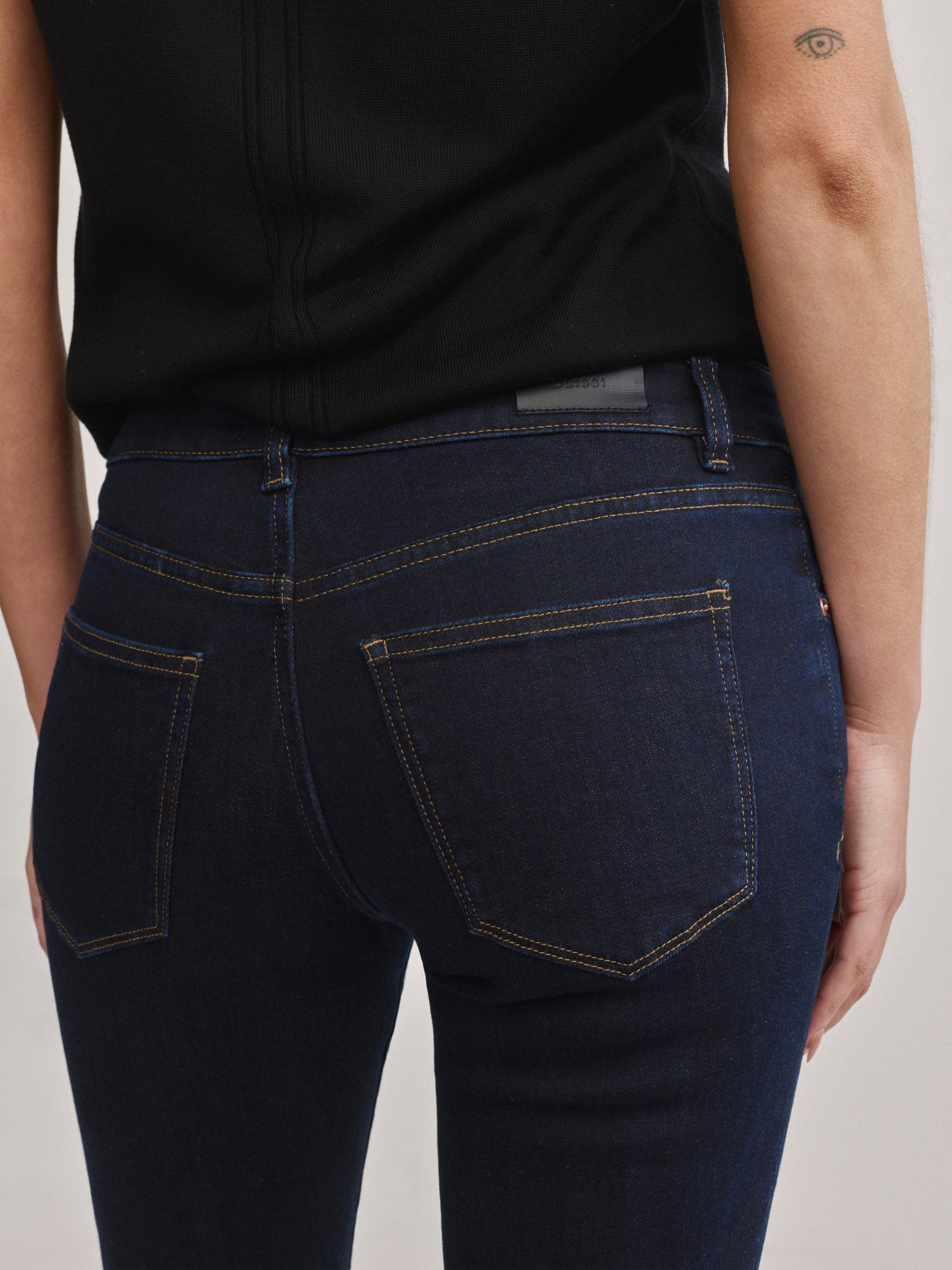 DL1961 Jessica Skinny low-rise jeans in dark indigo 'Harvest Moon', back pocket and logo patch close-up.